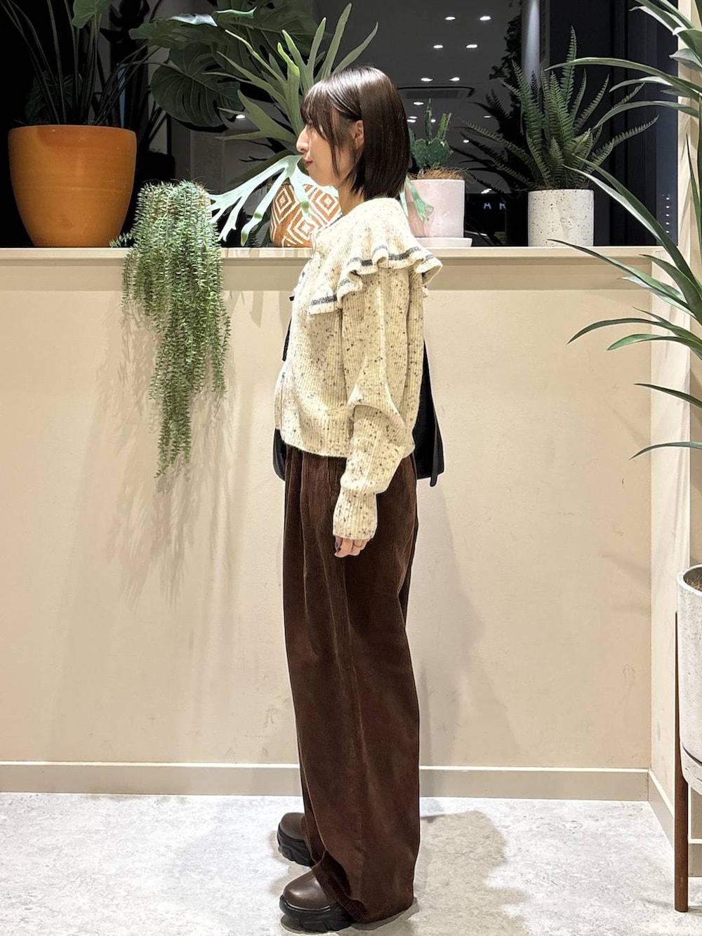 ブラック系のショルダーバッグ、ブラウン系のブーツ、ブラウン系のその他パンツを着用したレディースの秋コーディネートの2枚目の写真