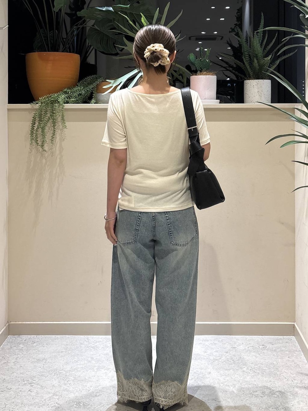 ホワイト系のTシャツ/カットソー、ブルー系のデニムパンツ、ブラック系のショルダーバッグを着用したレディースの夏コーディネートの3枚目の写真