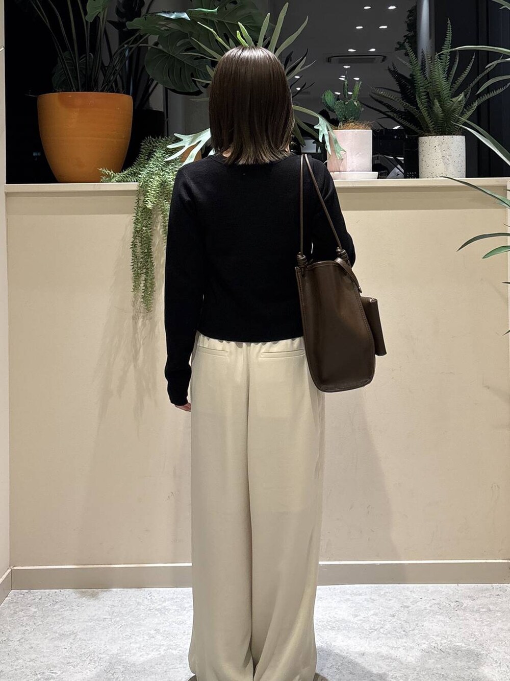 ブラック系のサンダル、ホワイト系のその他パンツ、ブラウン系のトートバッグを着用したレディースの春コーディネートの3枚目の写真