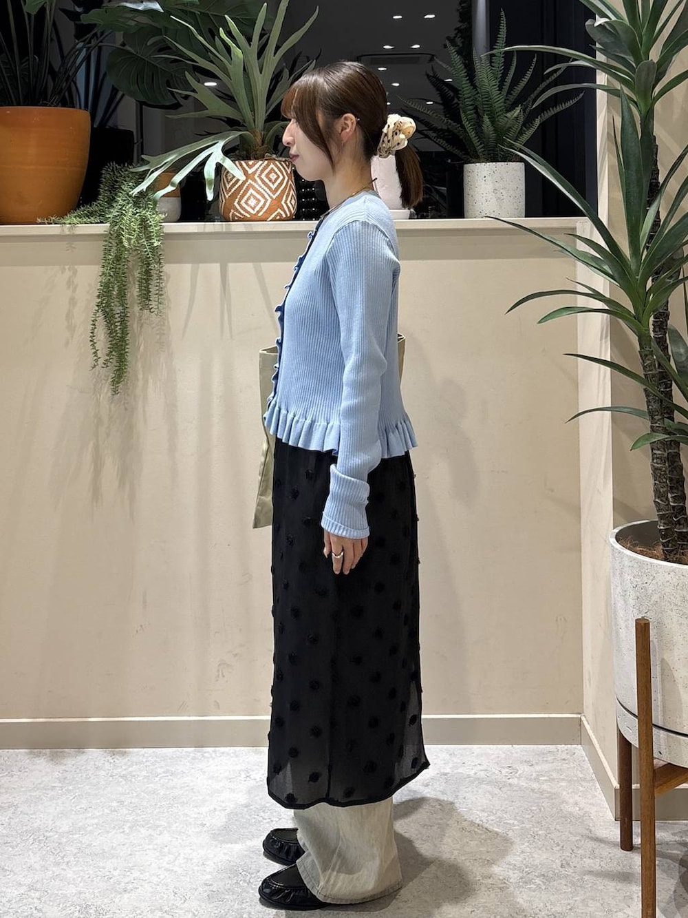 ベージュ系のデニムパンツ、ベージュ系のトートバッグ、ブラック系のローファーを着用したレディースの冬コーディネートの2枚目の写真