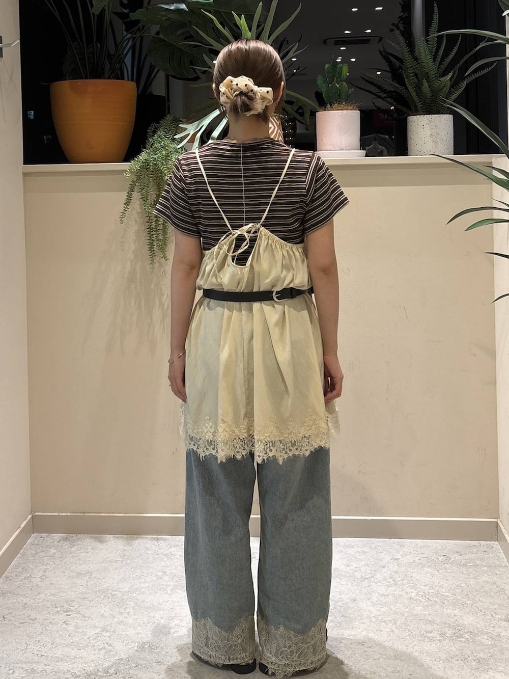 ブルー系のデニムパンツ、ブラウン系のTシャツ/カットソー、ブラック系のサンダルを着用したレディースの夏コーディネートの3枚目の写真