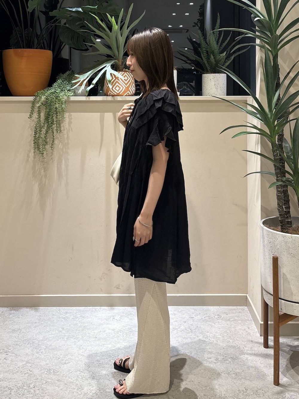 ブラック系のサンダル、ホワイト系のその他パンツ、ホワイト系のショルダーバッグを着用したレディースの夏コーディネートの2枚目の写真