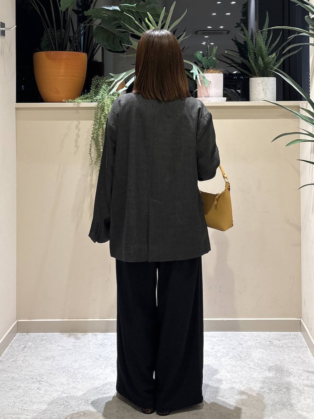 ブラック系のその他パンツ、その他のショルダーバッグ、ホワイト系のTシャツ/カットソーを着用したレディースの冬コーディネートの3枚目の写真