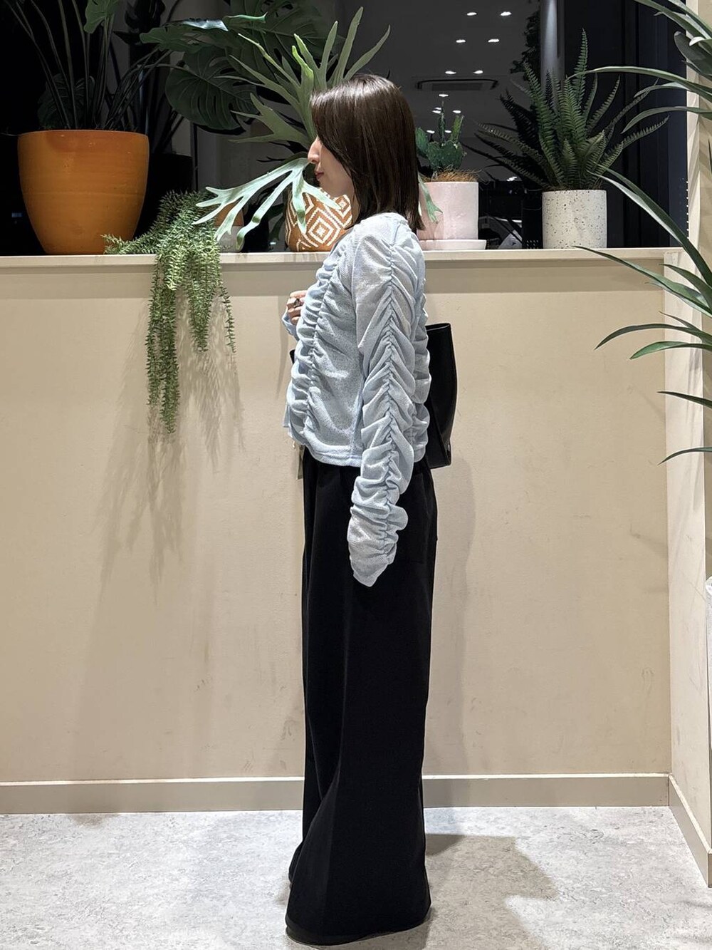 ブラック系のデニムパンツ、ブラック系のサンダル、ブルー系のカーディガン/ボレロを着用したレディースの春コーディネートの2枚目の写真