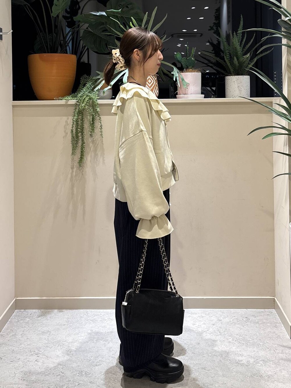 ブラック系のブーツ、ブルー系のその他パンツ、ブラック系のショルダーバッグを着用したレディースの冬コーディネートの4枚目の写真