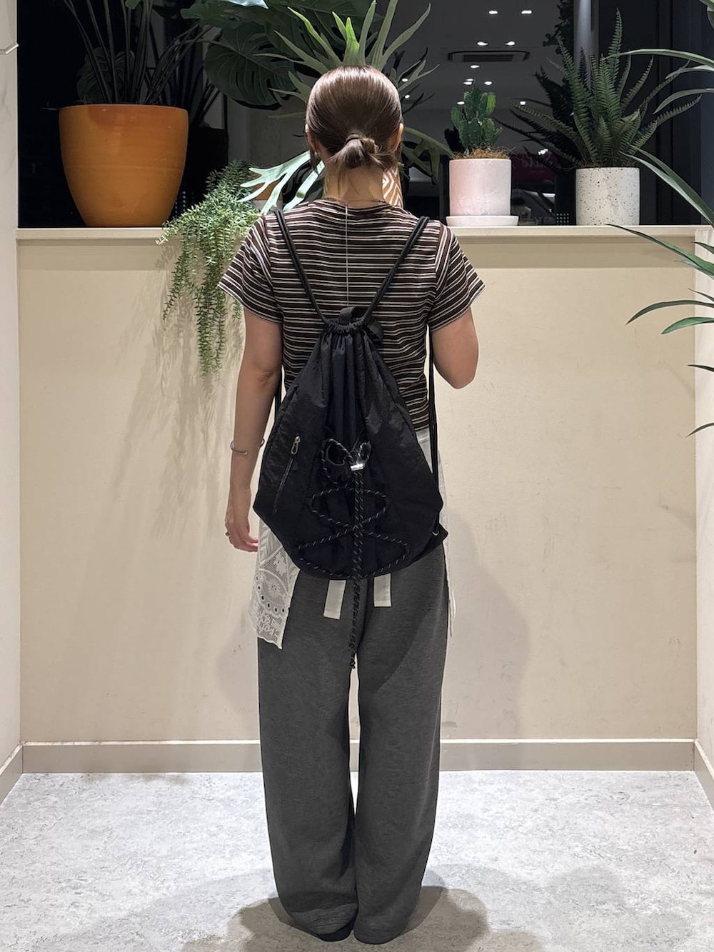 グレー系のスウェットパンツ、ブラウン系のTシャツ/カットソー、ブラック系のサンダルを着用したレディースの夏コーディネートの3枚目の写真