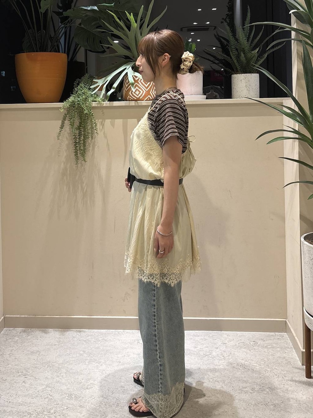 ブルー系のデニムパンツ、ブラウン系のTシャツ/カットソー、ブラック系のサンダルを着用したレディースの夏コーディネートの2枚目の写真