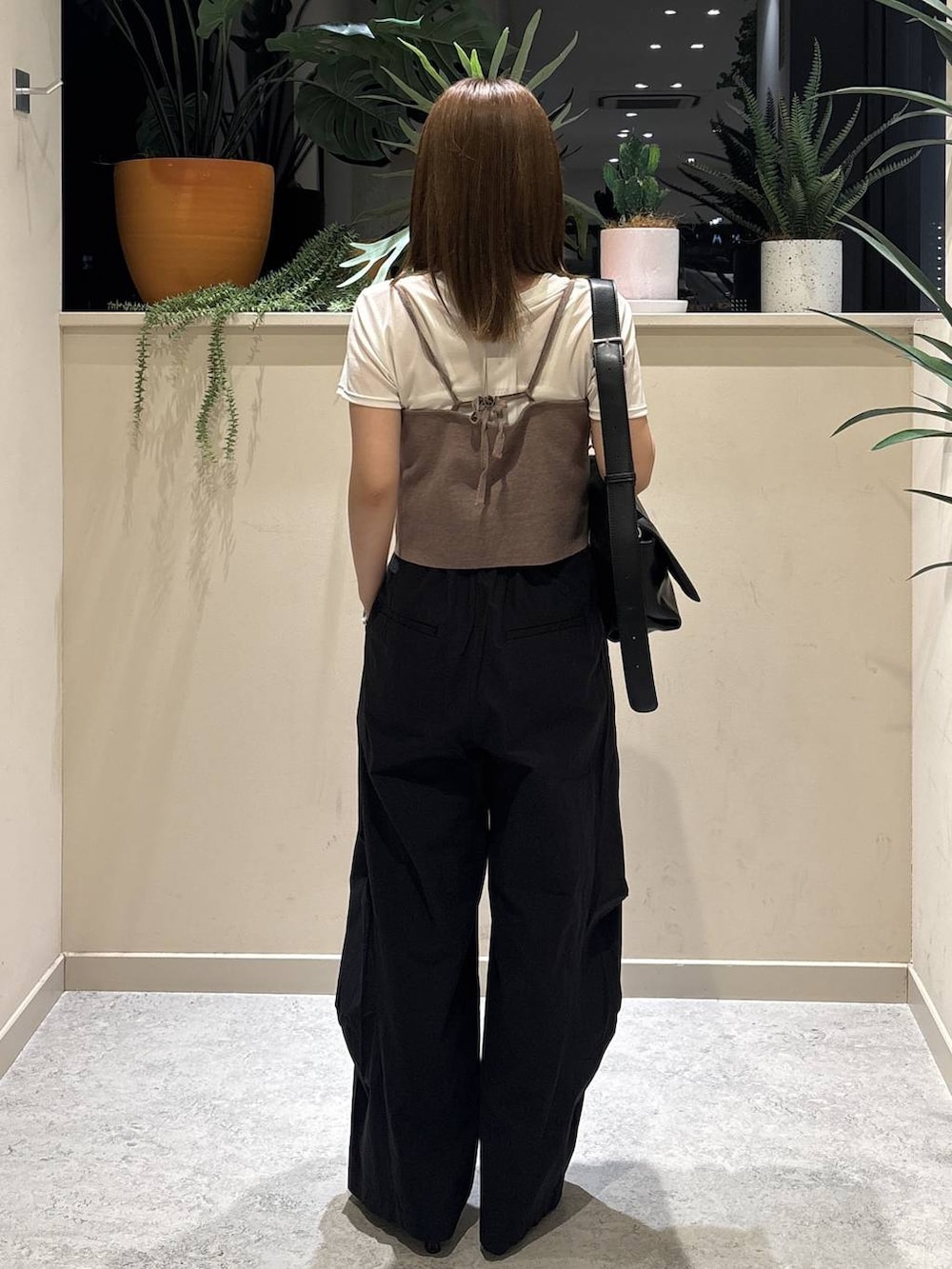 ブラック系のショルダーバッグ、ブラウン系のキャミソール、ブラック系のその他パンツを着用したレディースの夏コーディネートの3枚目の写真