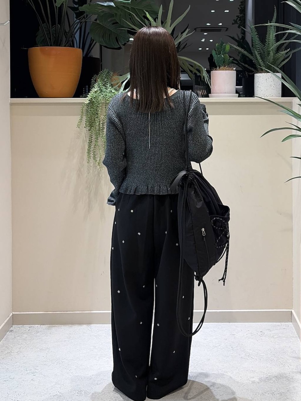ブラック系のバレエシューズ、イエロー系のボディバッグ/ウエストポーチ、ブラック系のカーディガン/ボレロを着用したレディースの秋コーディネートの3枚目の写真