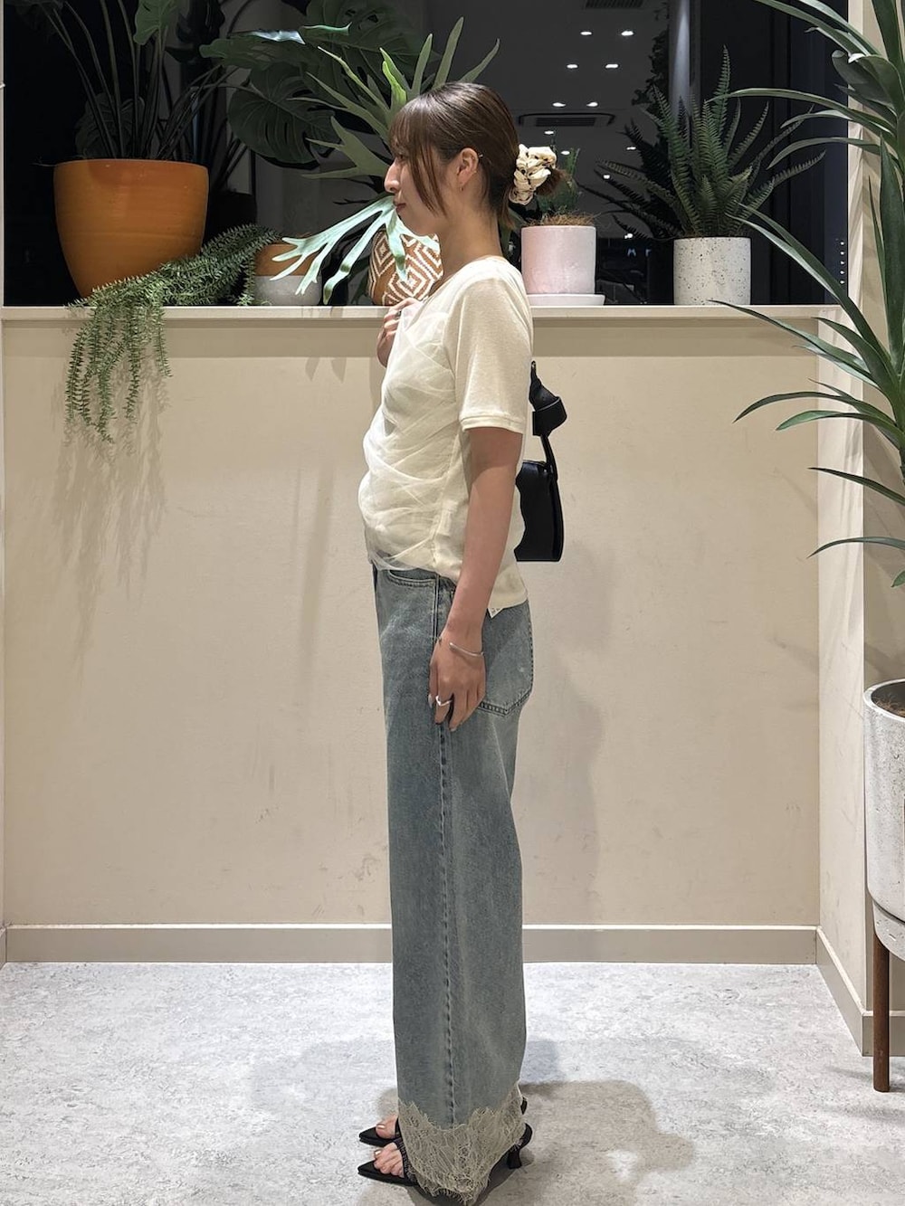 ホワイト系のTシャツ/カットソー、ブルー系のデニムパンツ、ブラック系のショルダーバッグを着用したレディースの夏コーディネートの2枚目の写真