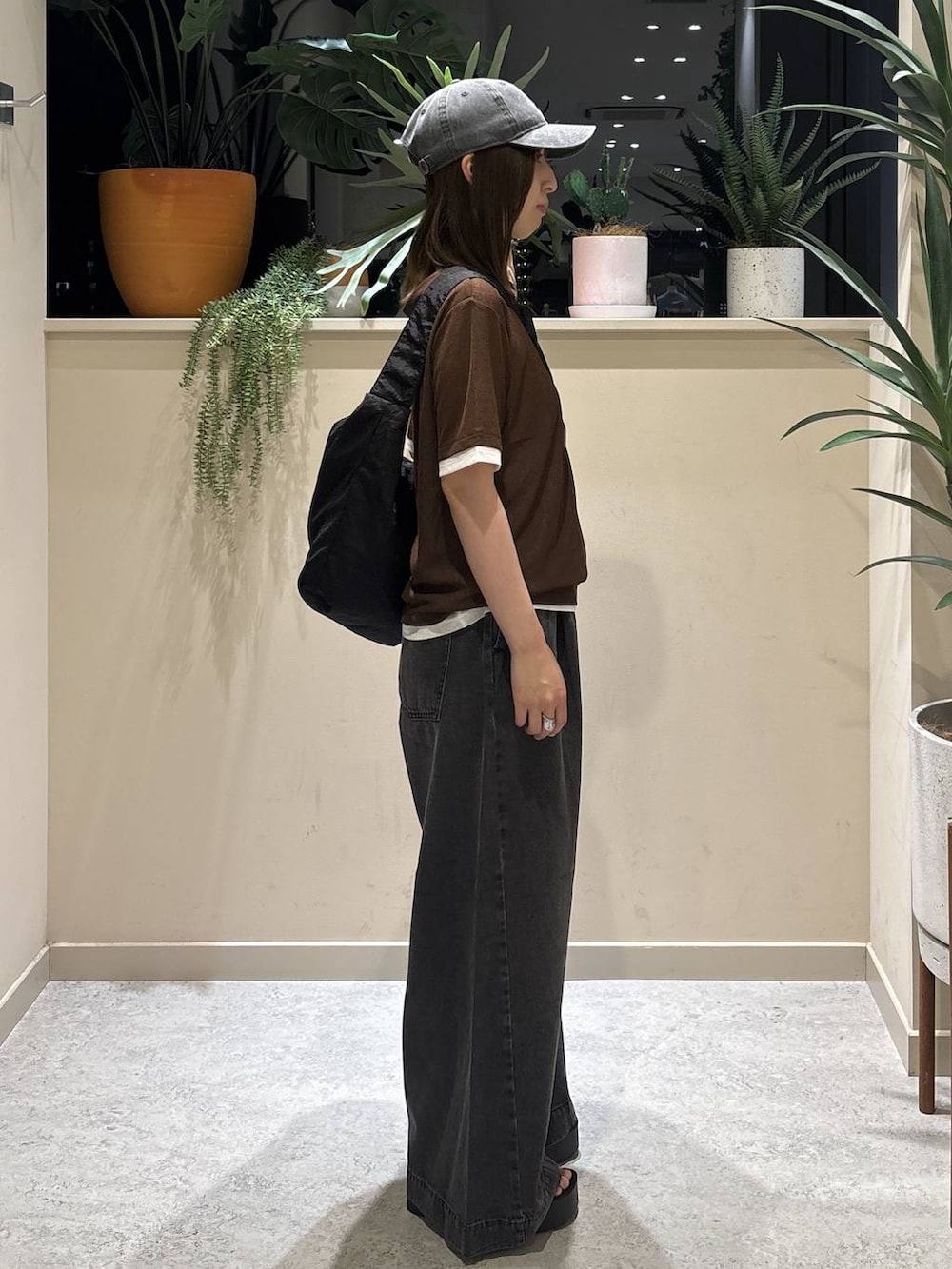 ブラック系のデニムパンツ、ブラック系のサンダル、ブラウン系のTシャツ/カットソーを着用したレディースの夏コーディネートの4枚目の写真