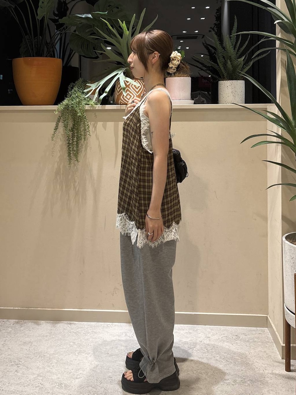 グレー系のスウェットパンツ、ブラウン系のキャミソール、シルバー系のタンクトップを着用したレディースの秋コーディネートの2枚目の写真