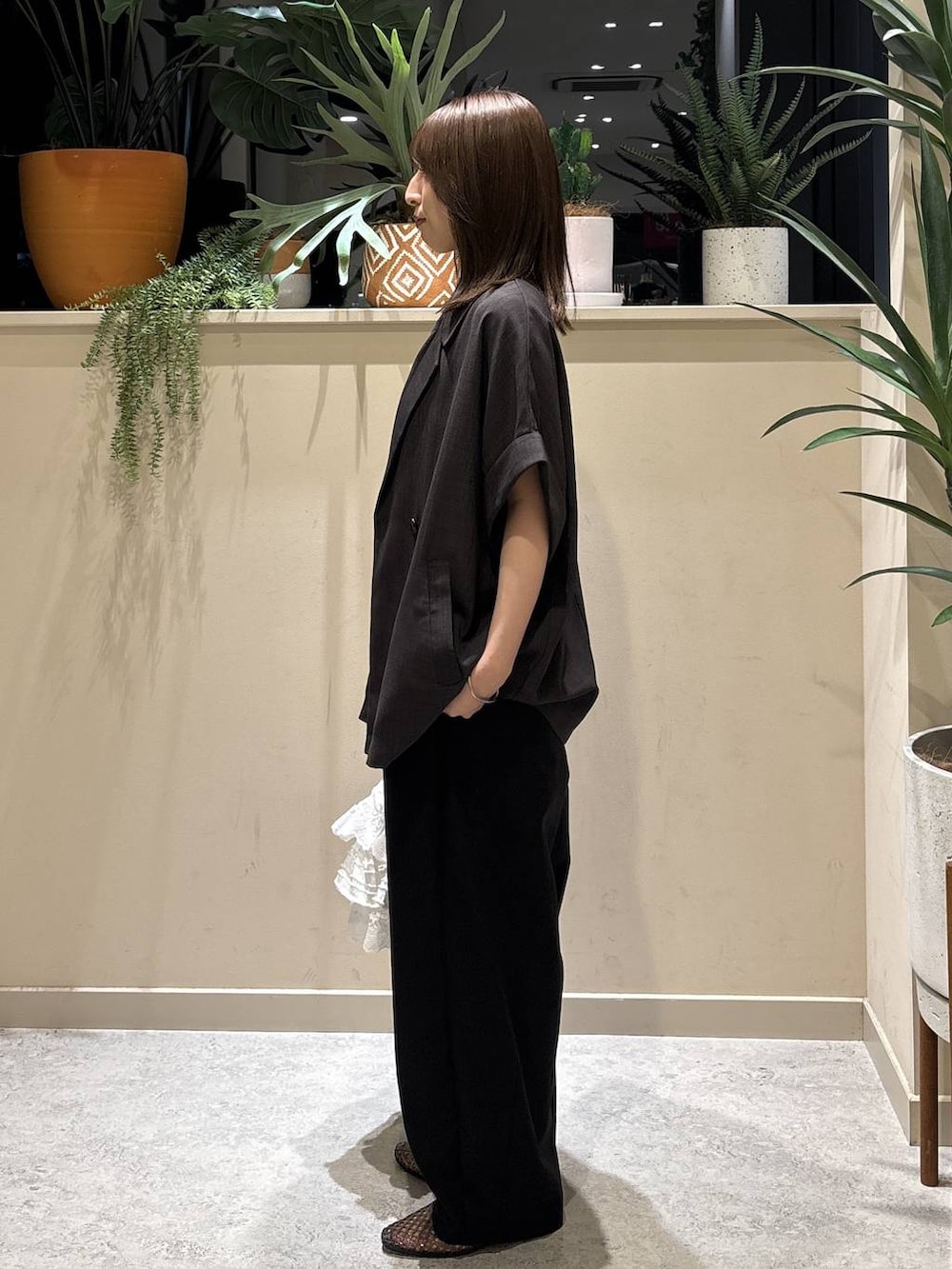 シルバー系のタンクトップ、ブラック系のその他パンツ、ホワイト系のハンドバッグを着用したレディースの夏コーディネートの2枚目の写真
