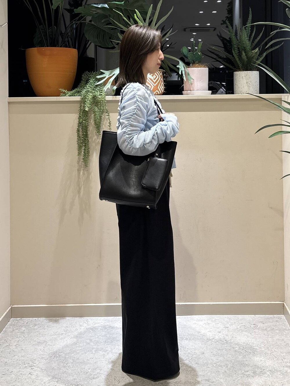 ブラック系のデニムパンツ、ブラック系のサンダル、ブルー系のカーディガン/ボレロを着用したレディースの春コーディネートの4枚目の写真