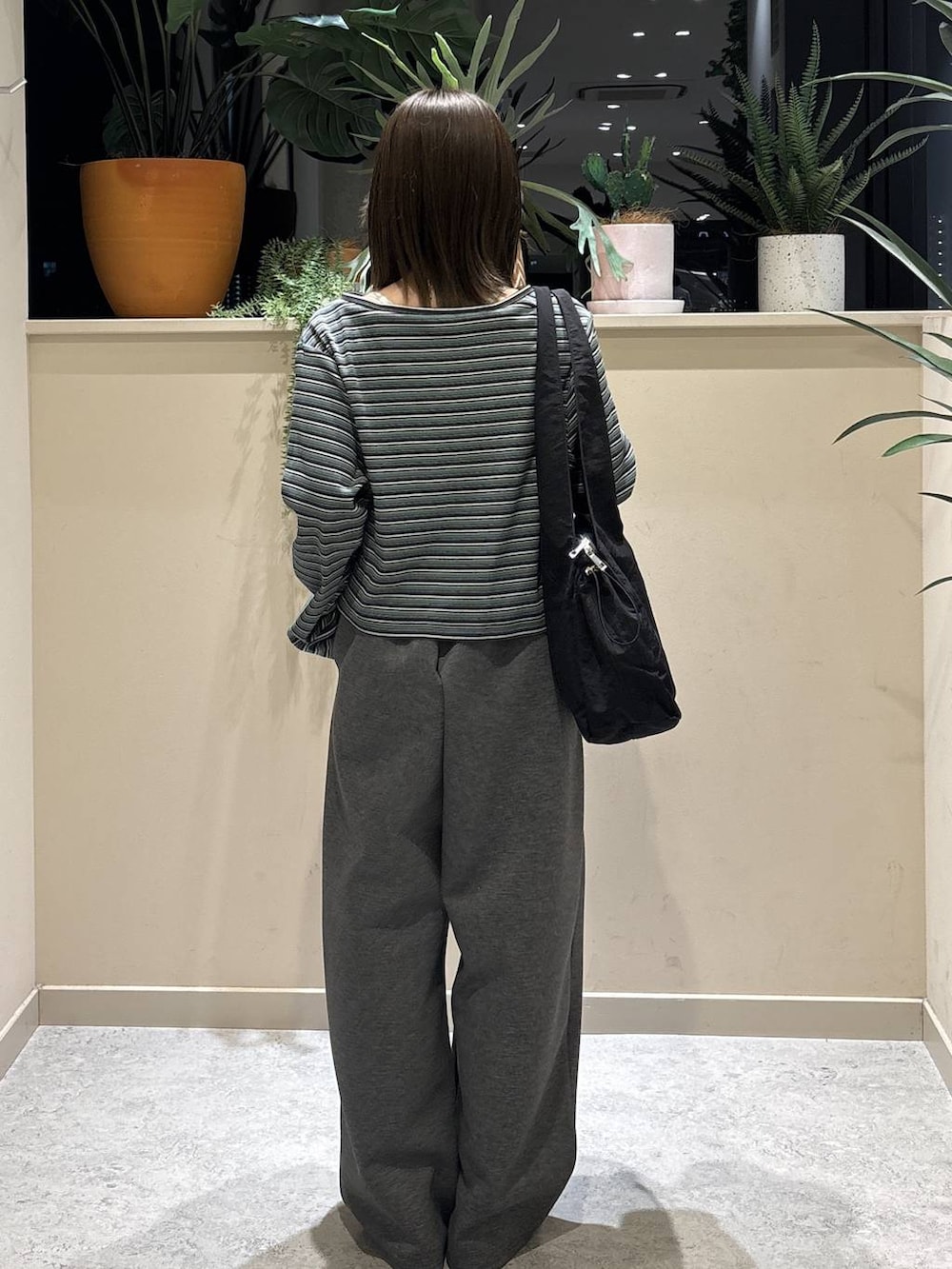 グレー系のスウェットパンツ、ブラック系のローファー、ブラック系のトートバッグを着用したレディースの春コーディネートの3枚目の写真
