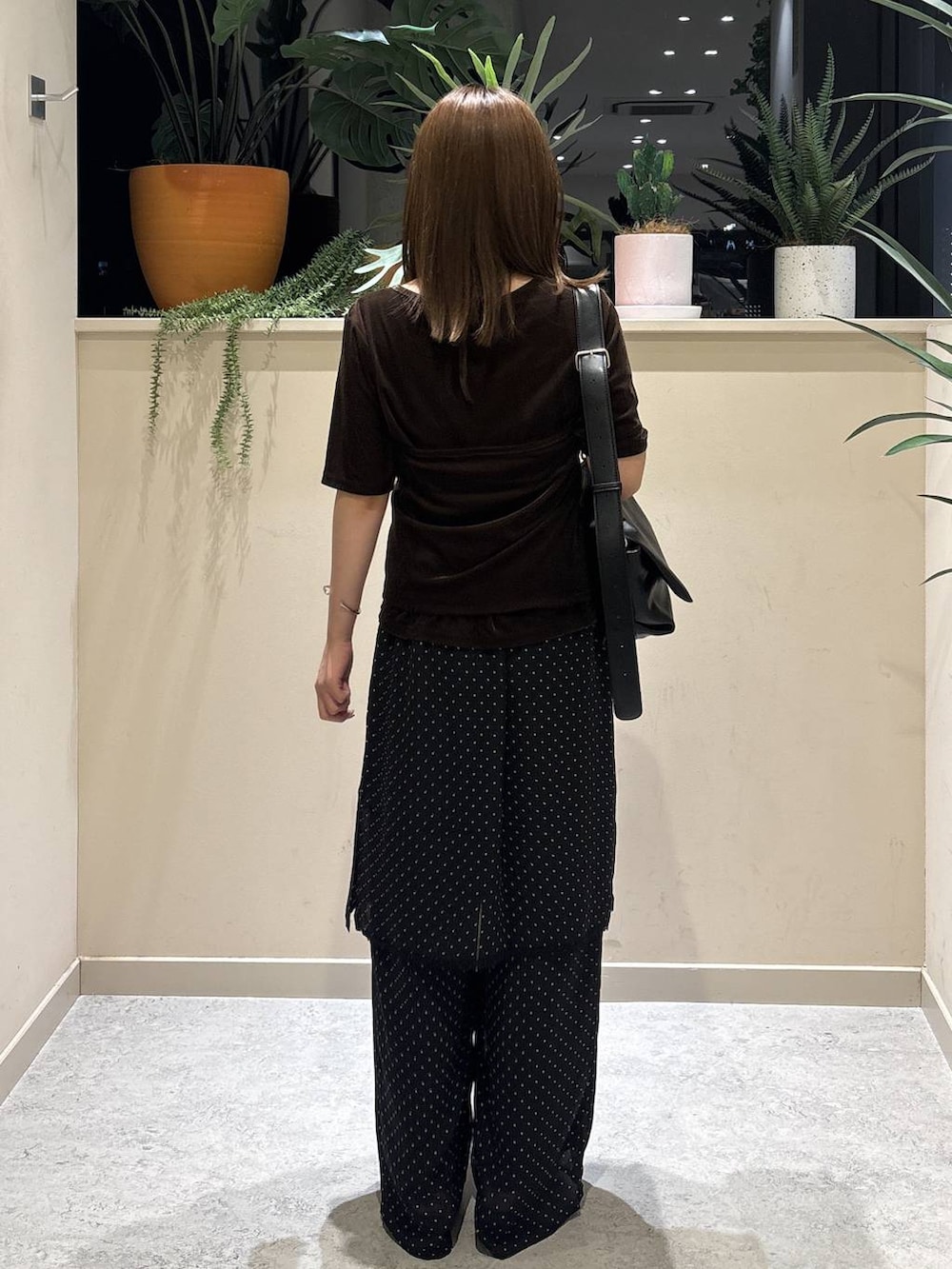 ブラック系のショルダーバッグ、ブラウン系のTシャツ/カットソー、ブラック系のサンダルを着用したレディースの夏コーディネートの3枚目の写真