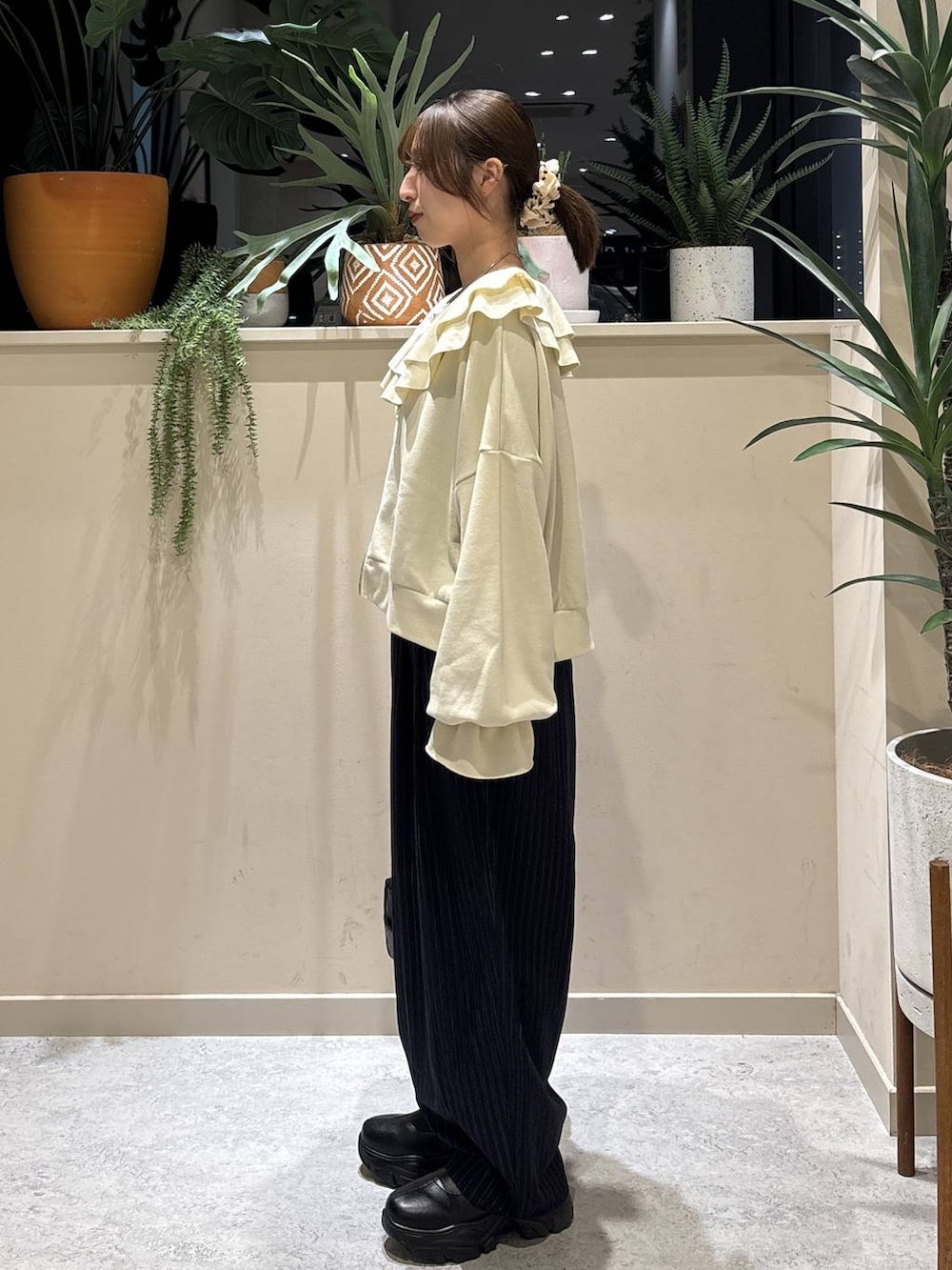 ブラック系のブーツ、ブルー系のその他パンツ、ブラック系のショルダーバッグを着用したレディースの冬コーディネートの2枚目の写真