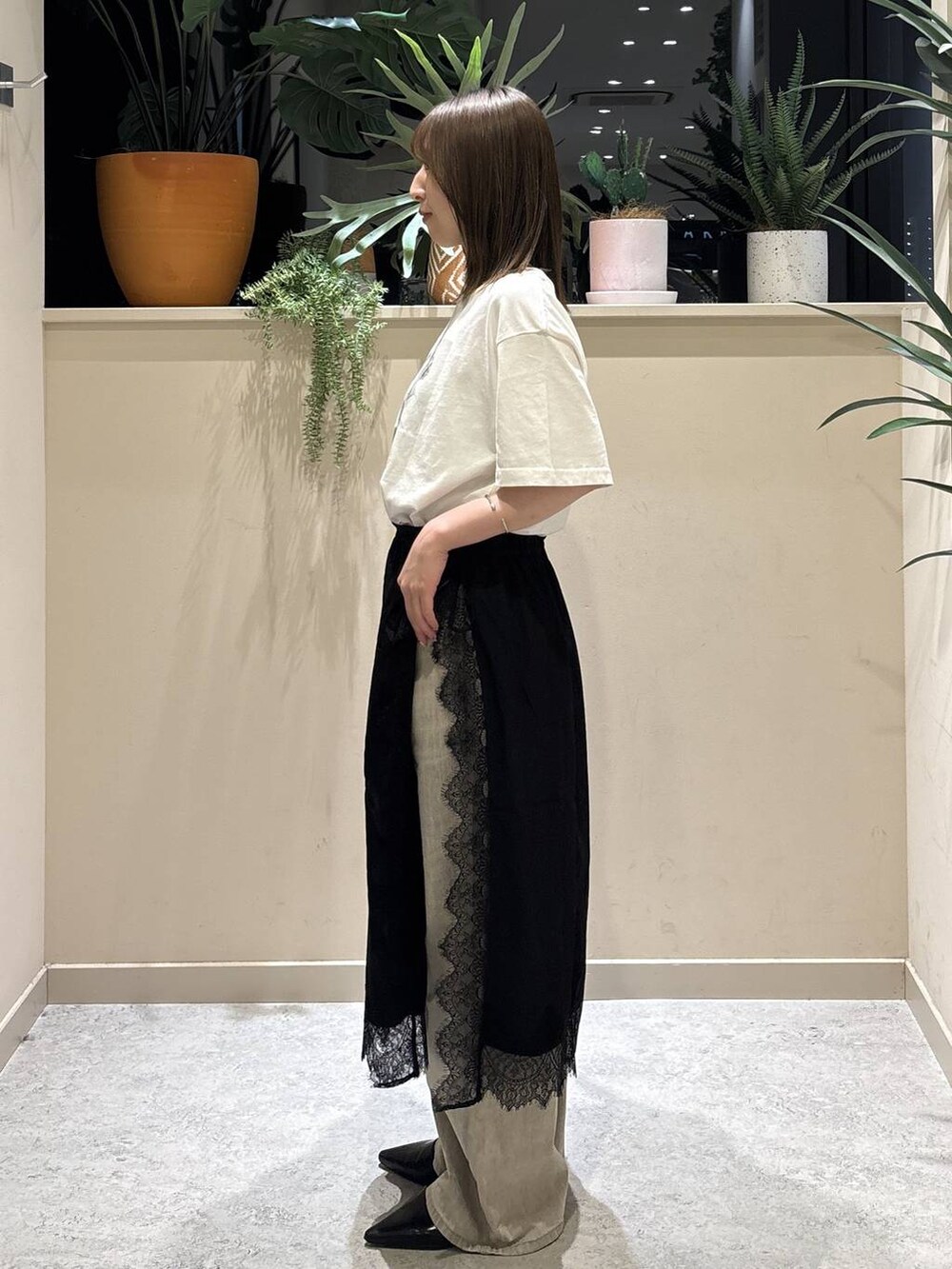 ベージュ系のデニムパンツ、ブラック系のサンダル、ホワイト系のTシャツ/カットソーを着用したレディースの夏コーディネートの2枚目の写真