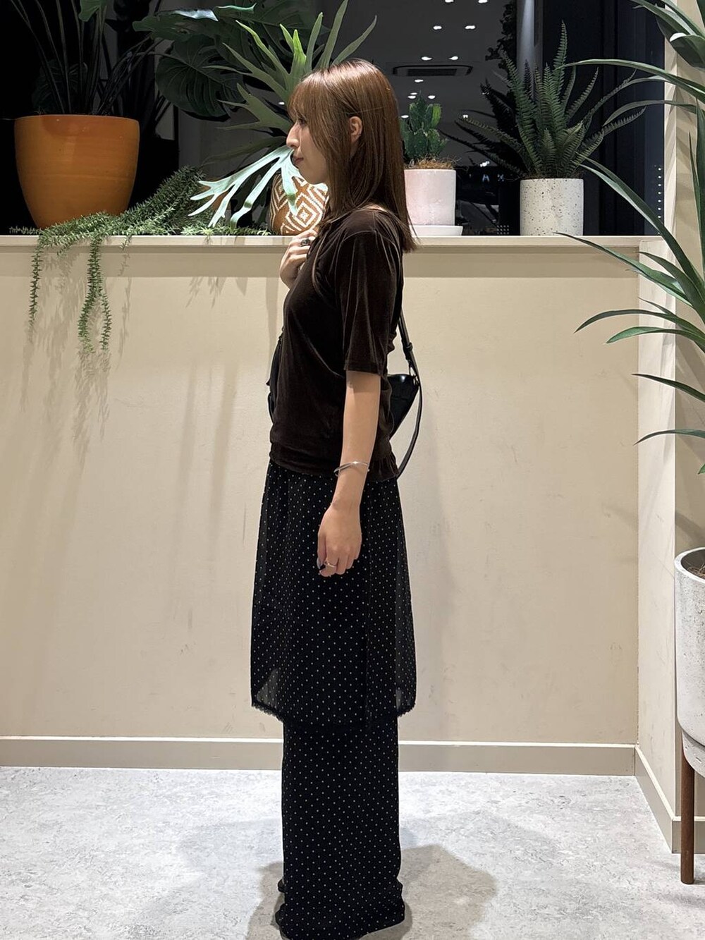 ブラック系のショルダーバッグ、ブラウン系のTシャツ/カットソー、ブラック系のサンダルを着用したレディースの夏コーディネートの2枚目の写真