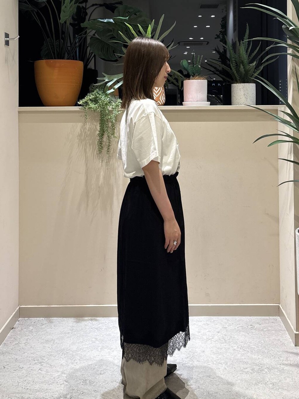 ベージュ系のデニムパンツ、ブラック系のサンダル、ホワイト系のTシャツ/カットソーを着用したレディースの夏コーディネートの3枚目の写真