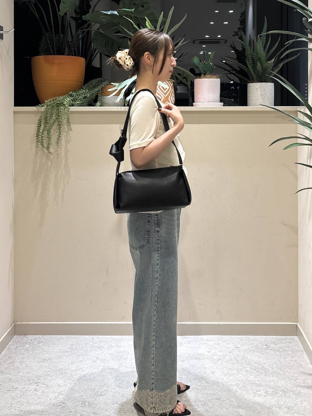 ホワイト系のTシャツ/カットソー、ブルー系のデニムパンツ、ブラック系のショルダーバッグを着用したレディースの夏コーディネートの4枚目の写真