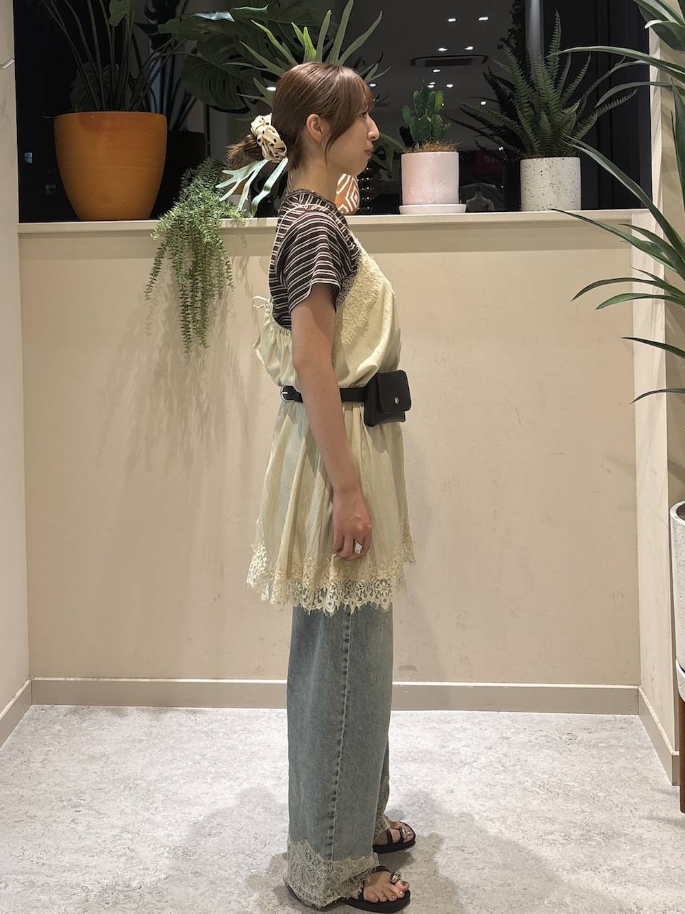 ブルー系のデニムパンツ、ブラウン系のTシャツ/カットソー、ブラック系のサンダルを着用したレディースの夏コーディネートの4枚目の写真