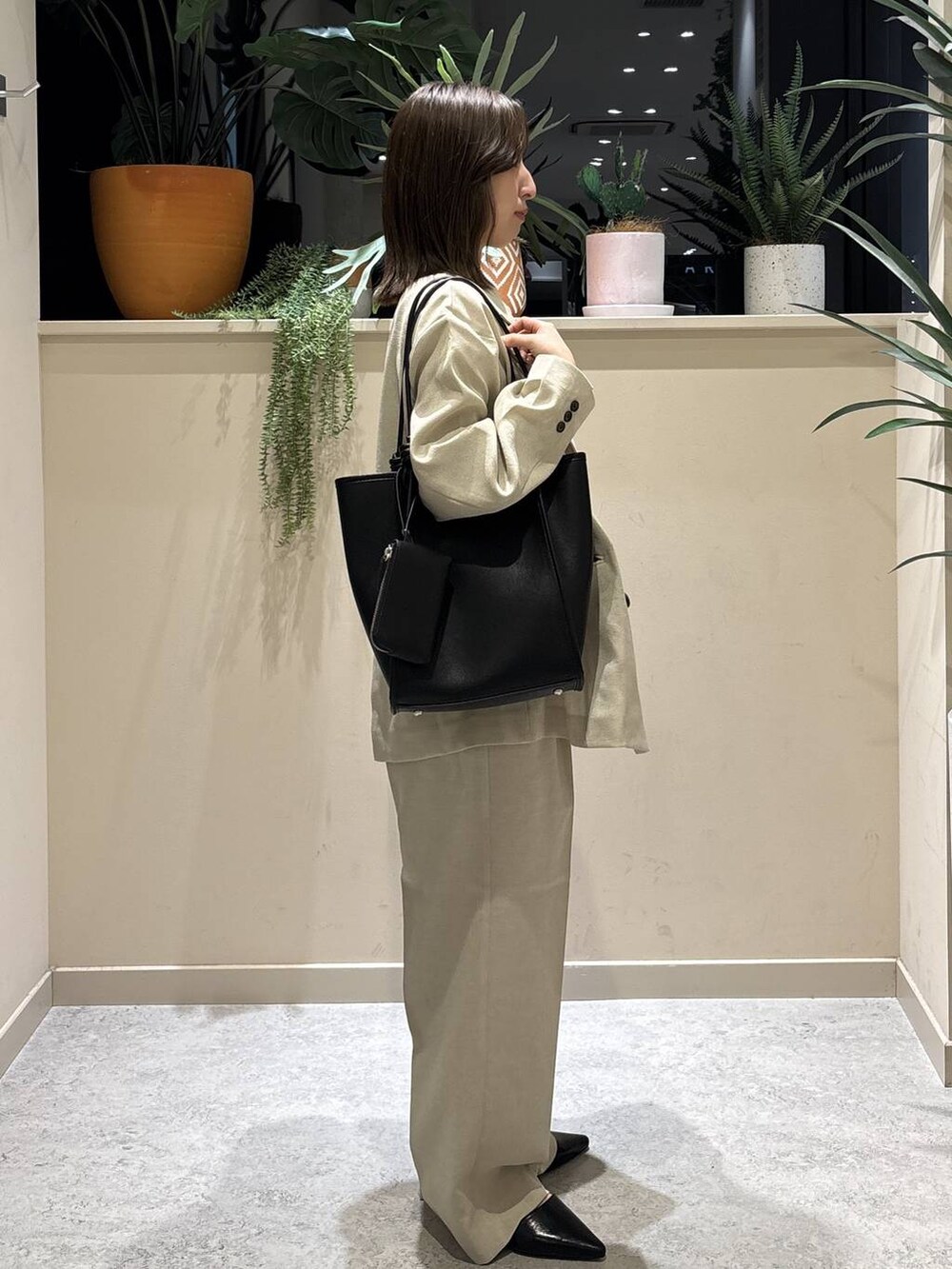 ベージュ系のその他アウター、ベージュ系のその他パンツ、ブラック系のトートバッグを着用したレディースの春コーディネートの4枚目の写真