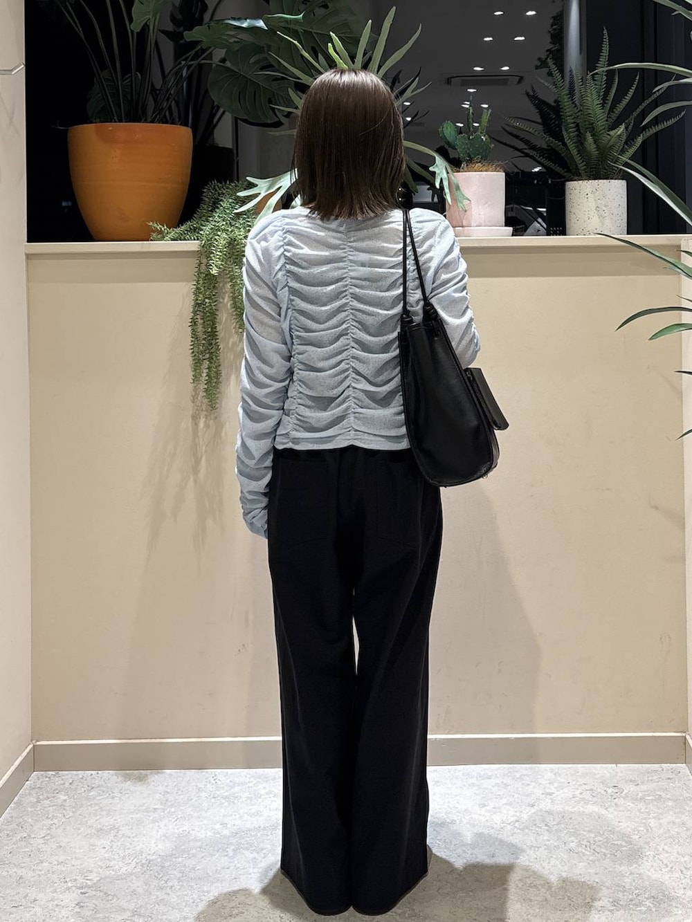 ブラック系のデニムパンツ、ブラック系のサンダル、ブルー系のカーディガン/ボレロを着用したレディースの春コーディネートの3枚目の写真