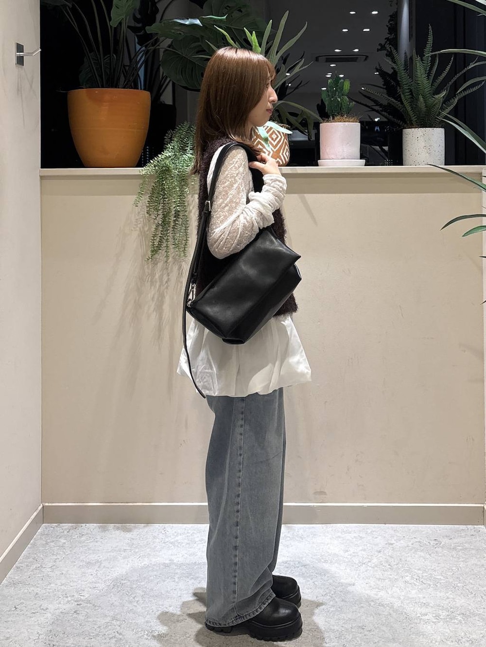 ブラック系のブーツ、ブラック系のショルダーバッグ、ホワイト系のTシャツ/カットソーを着用したレディースの秋コーディネートの4枚目の写真