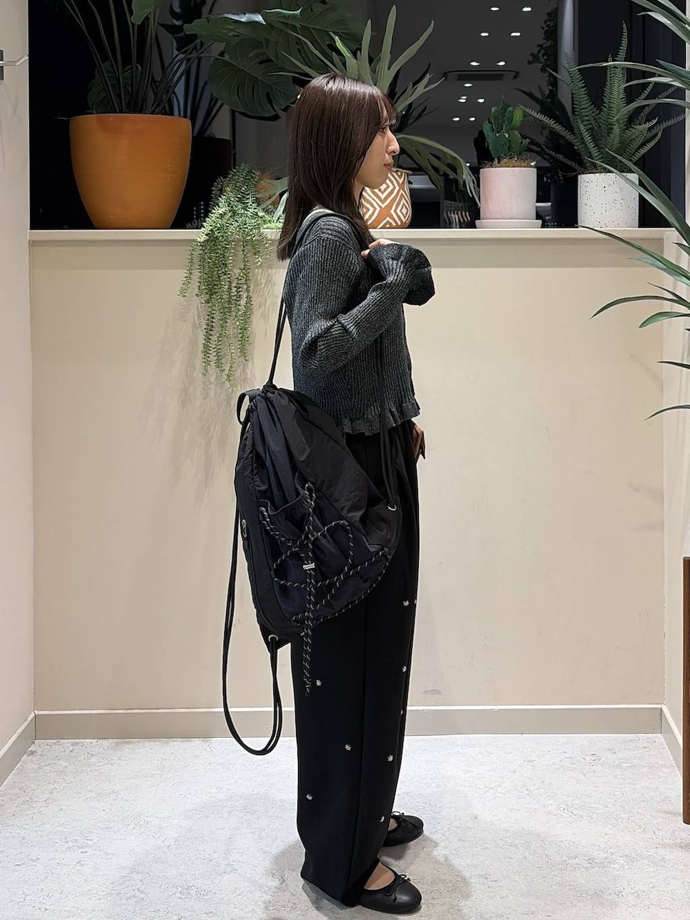 ブラック系のバレエシューズ、イエロー系のボディバッグ/ウエストポーチ、ブラック系のカーディガン/ボレロを着用したレディースの秋コーディネートの4枚目の写真