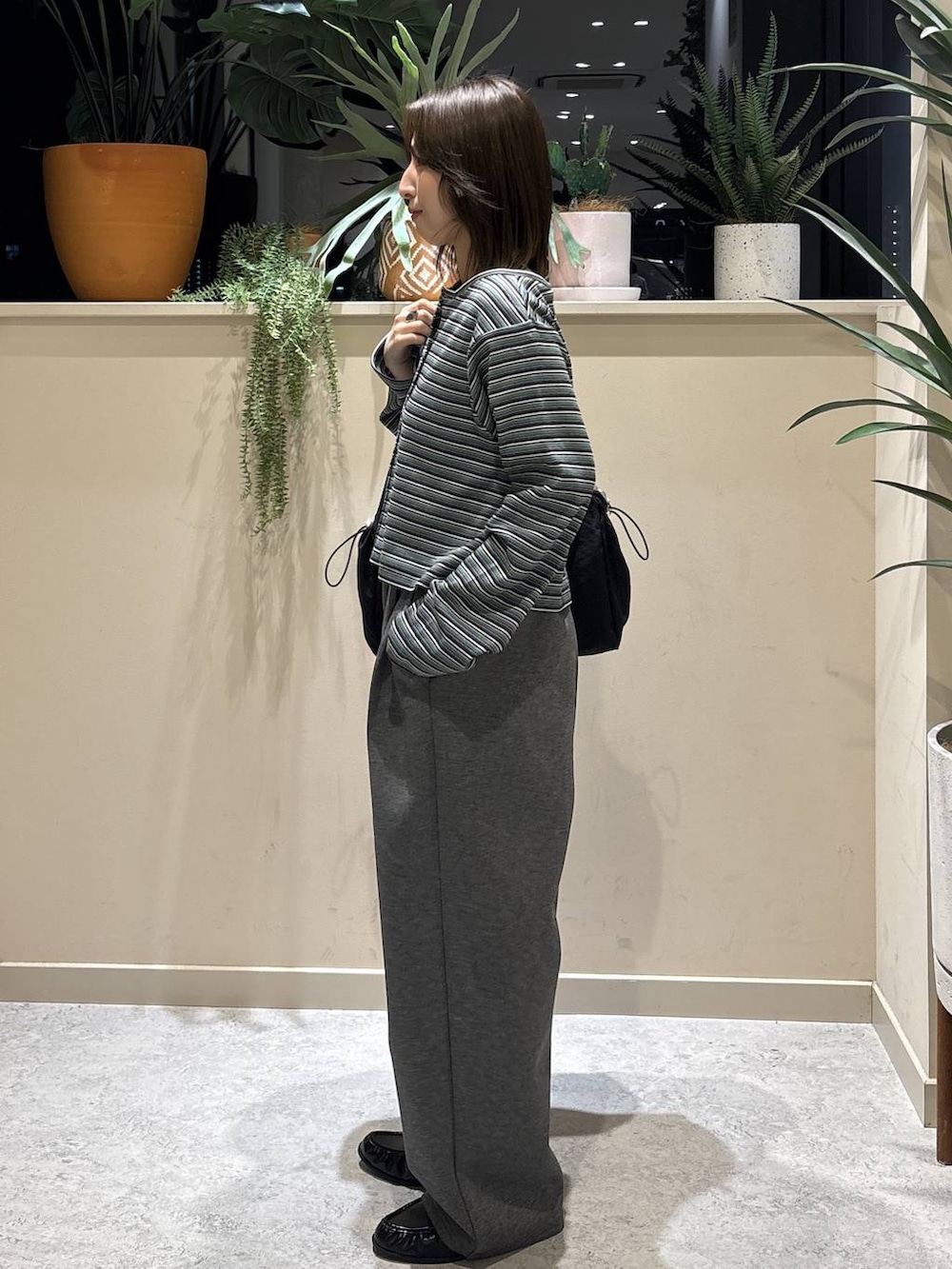 グレー系のスウェットパンツ、ブラック系のローファー、ブラック系のトートバッグを着用したレディースの春コーディネートの2枚目の写真