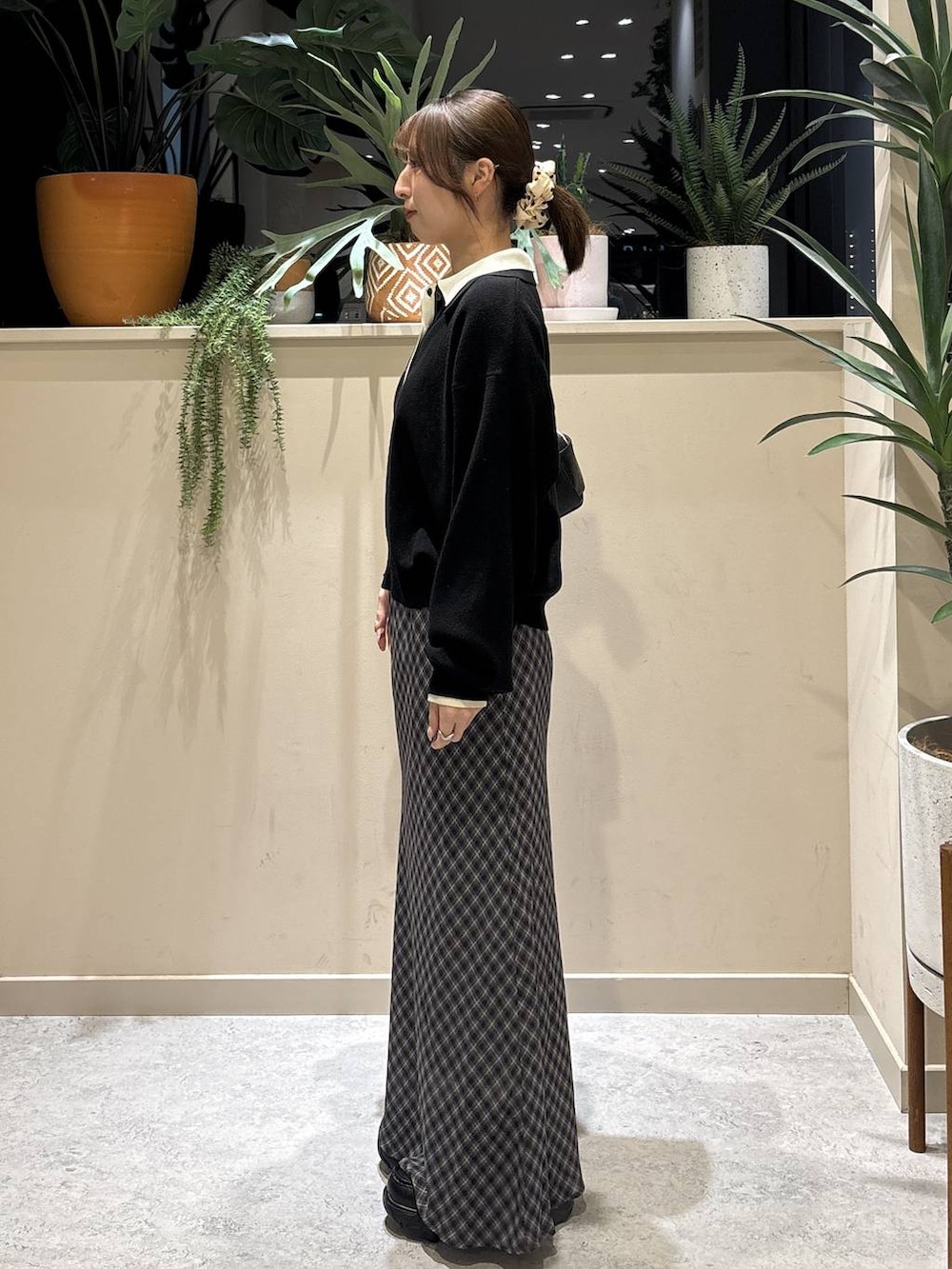 ブラック系のブーツ、ブラック系のショルダーバッグ、ブラック系のニット/セーターを着用したレディースの冬コーディネートの2枚目の写真