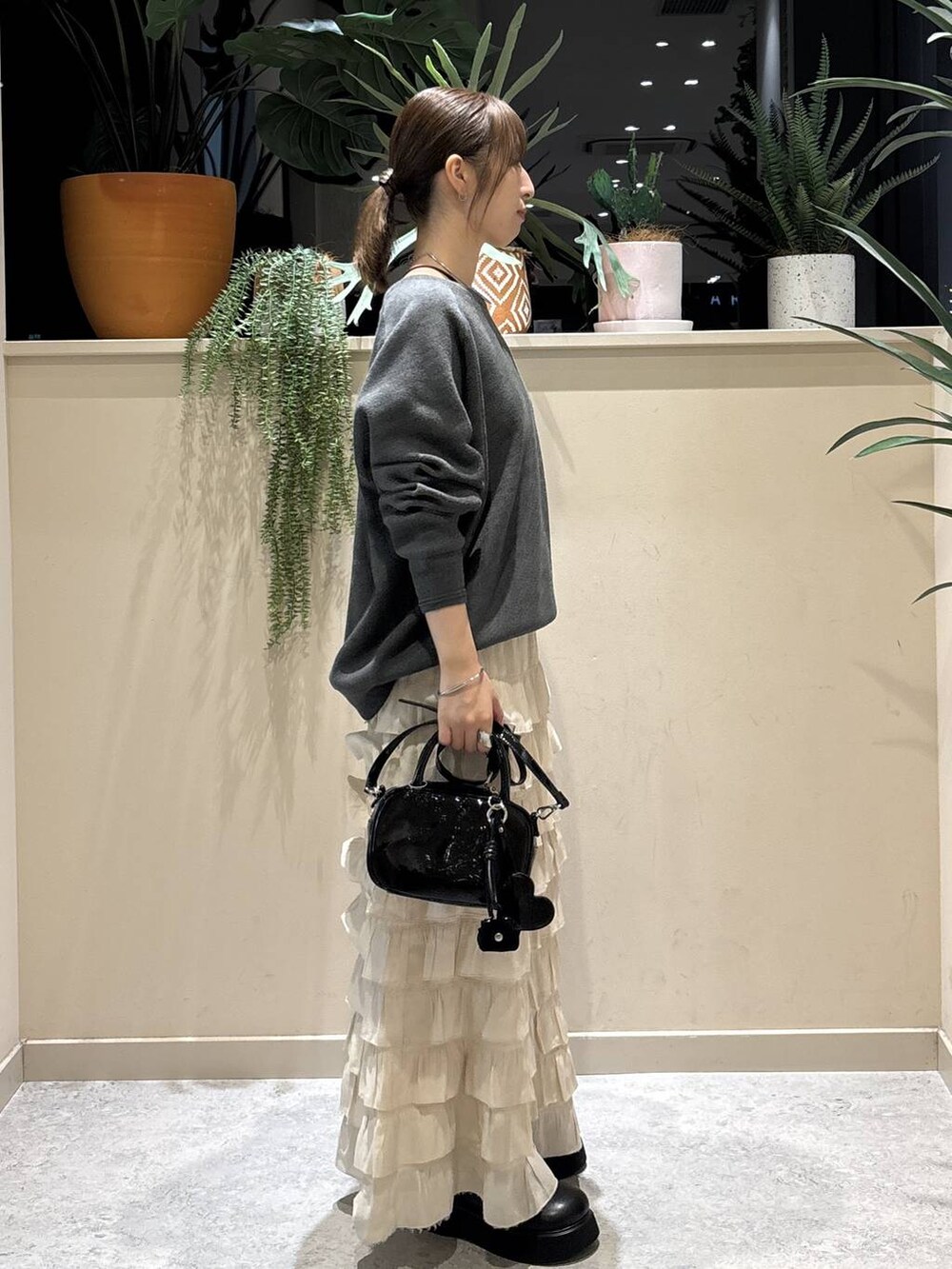 ホワイト系のスカート、ブラック系のサンダル、グレー系のニット/セーターを着用したレディースの秋コーディネートの3枚目の写真