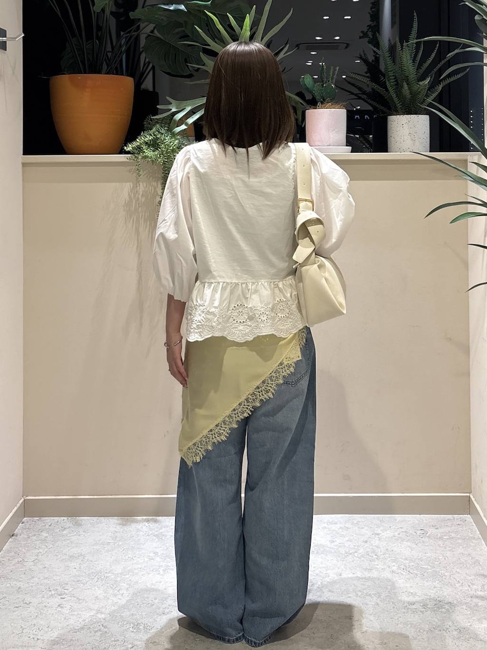 ブルー系のデニムパンツ、ホワイト系のサンダル、ホワイト系のシャツ/ブラウスを着用したレディースの夏コーディネートの3枚目の写真