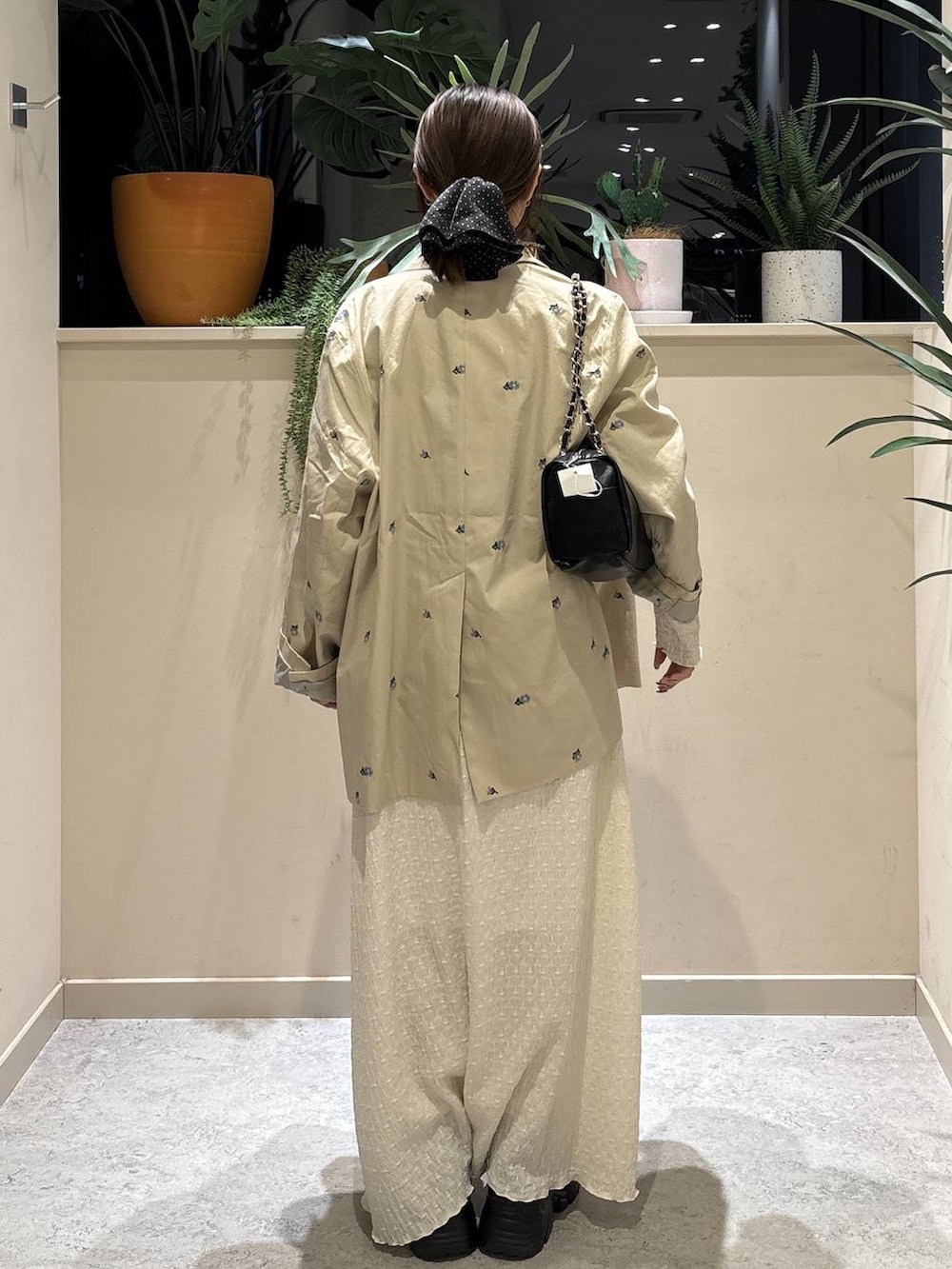 ブラック系のショルダーバッグ、ブラック系のローファー、ホワイト系のワンピースを着用したレディースの春コーディネートの3枚目の写真