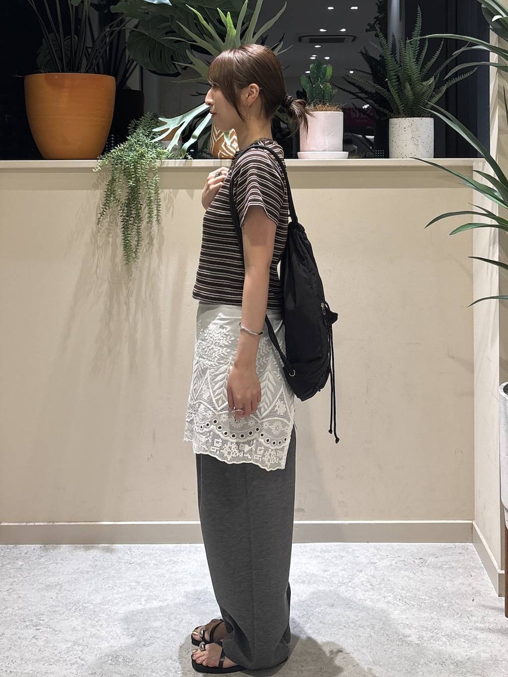 グレー系のスウェットパンツ、ブラウン系のTシャツ/カットソー、ブラック系のサンダルを着用したレディースの夏コーディネートの2枚目の写真