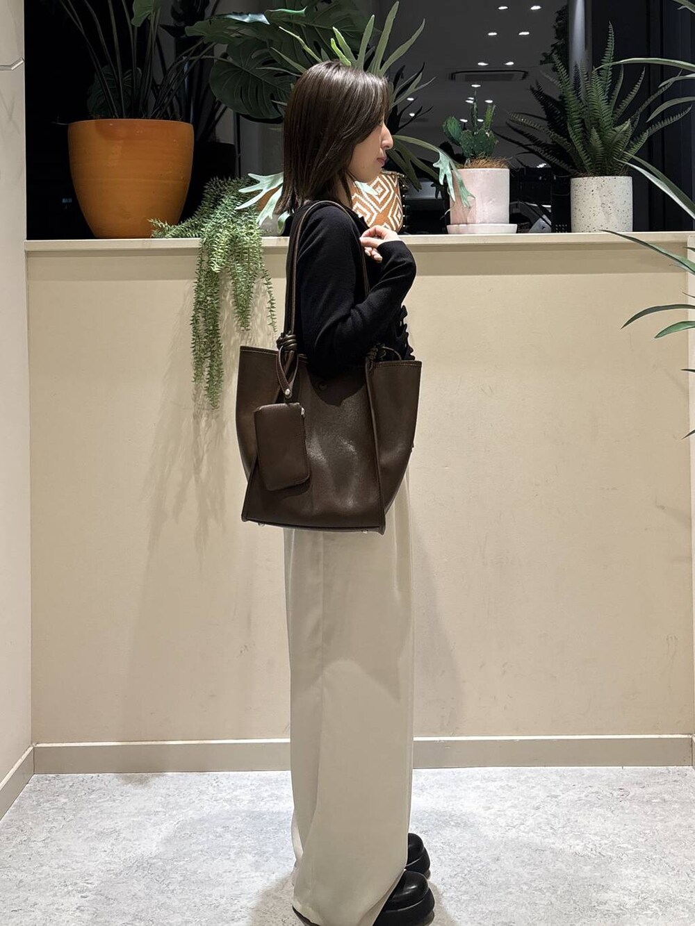 ブラック系のサンダル、ホワイト系のその他パンツ、ブラウン系のトートバッグを着用したレディースの春コーディネートの4枚目の写真
