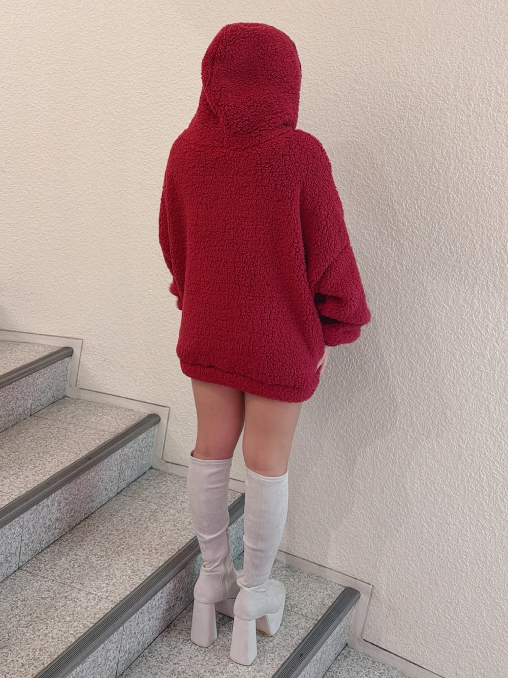 レッド系のパーカー、ホワイト系のブーツ、その他のデニムスカートを着用したレディースの秋コーディネートの3枚目の写真