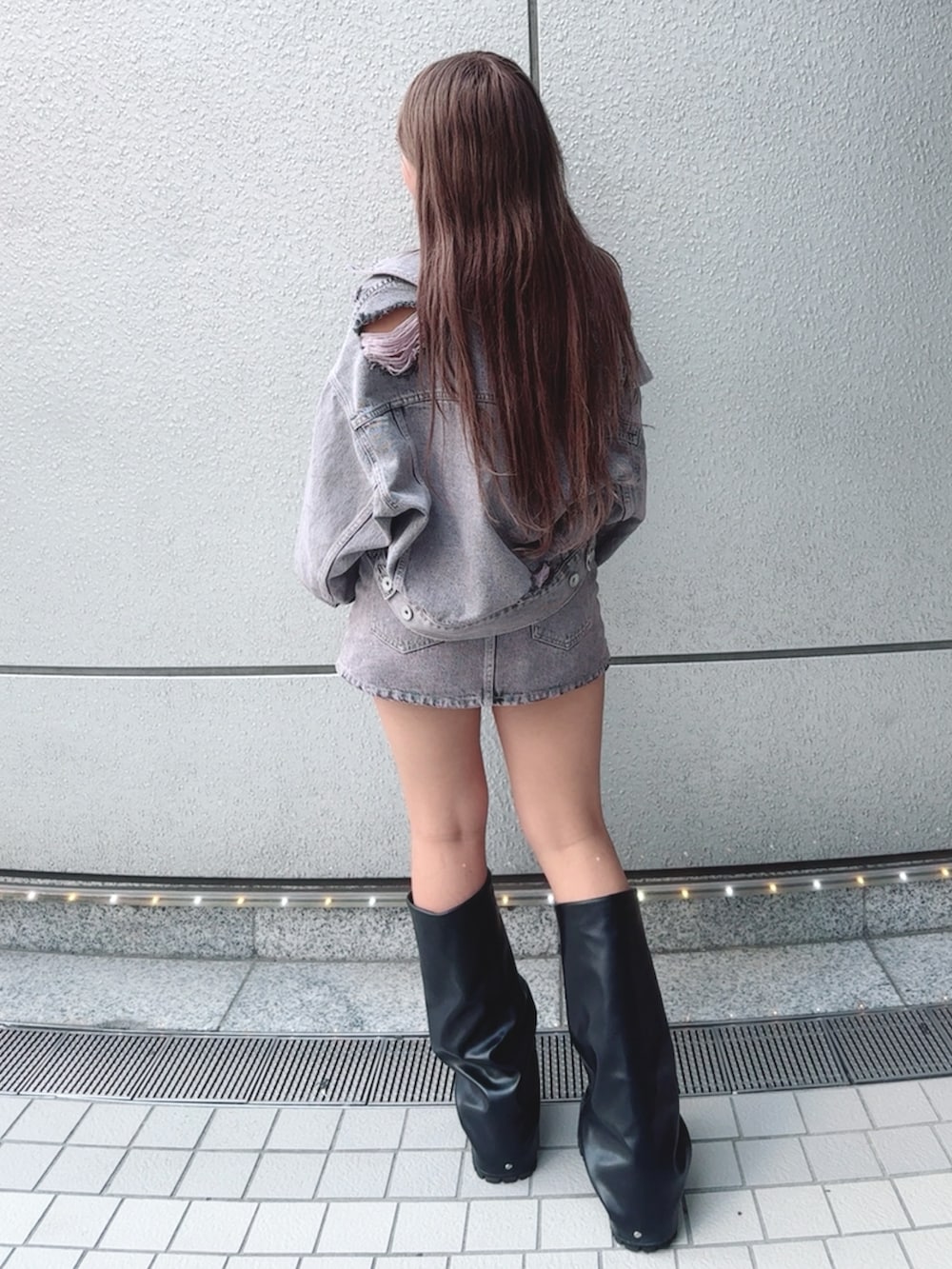 ピンク系のデニムジャケット、ブラック系のキャミソール、ピンク系のデニムスカートを着用したレディースの夏コーディネートの3枚目の写真