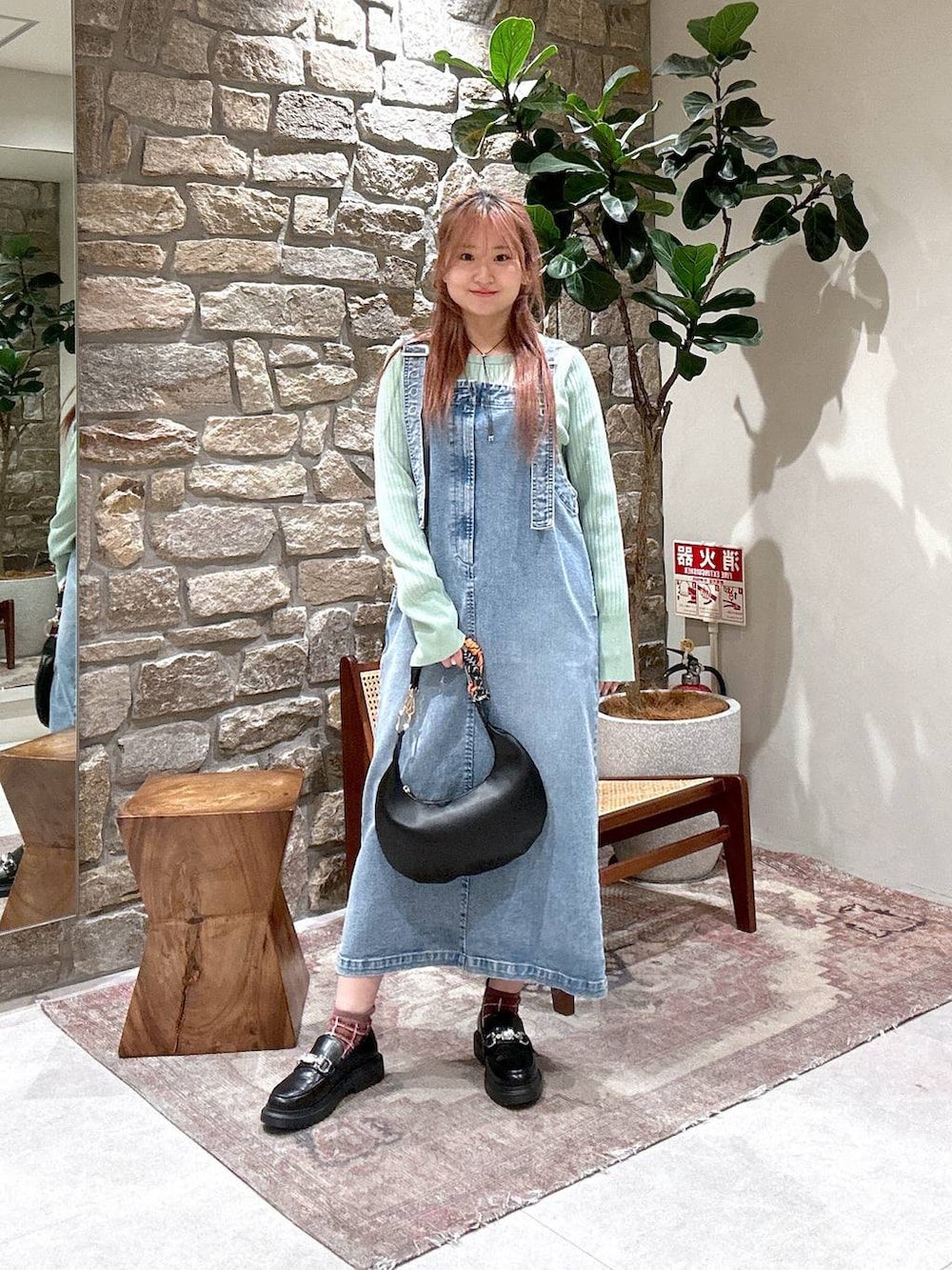 グリーン系のニット/セーター、その他のローファー、ブルー系のサロペット/オーバーオールを着用したレディースの冬コーディネートの2枚目の写真