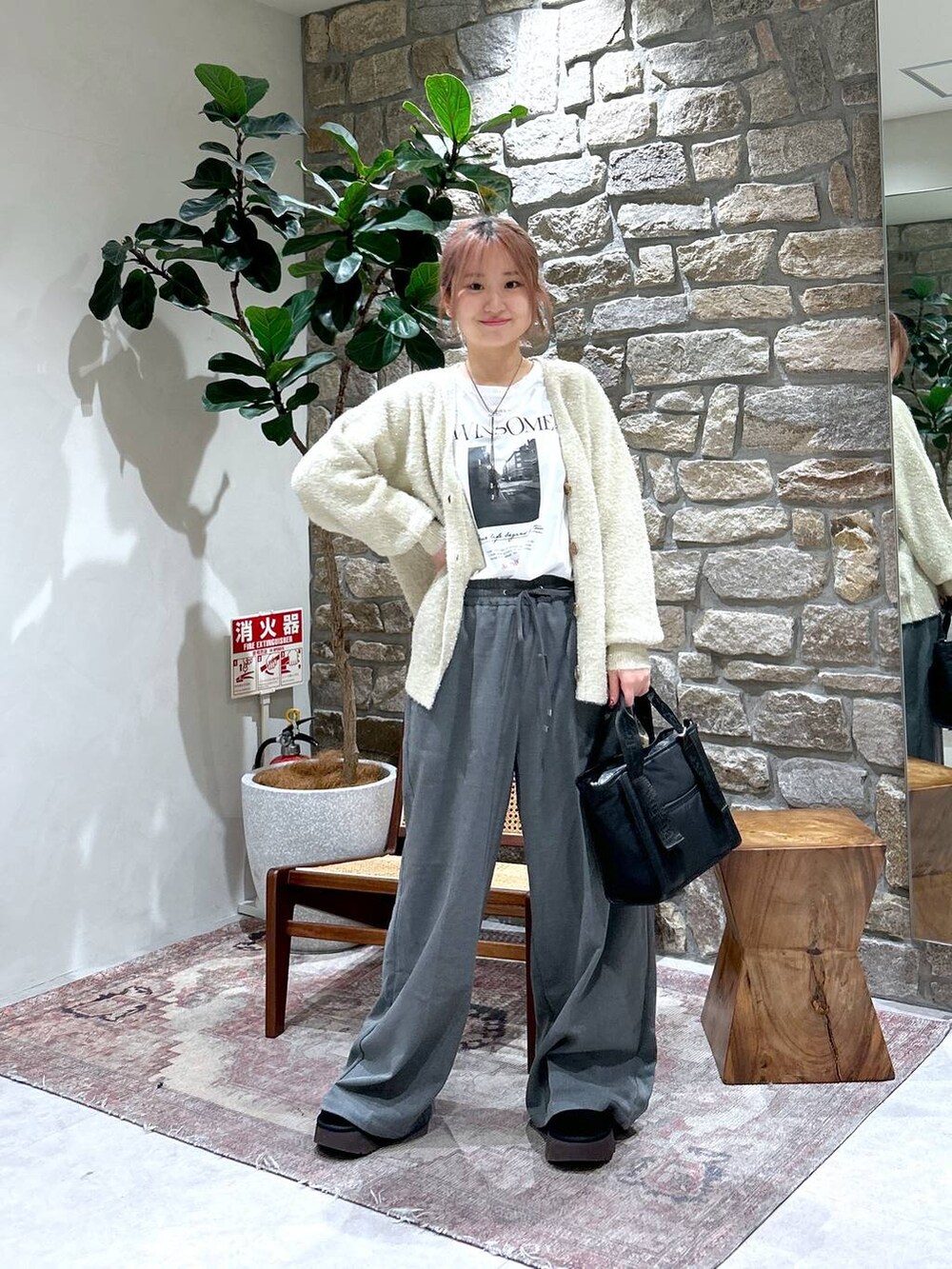 グレー系のその他パンツ、ブラック系のトートバッグ、ホワイト系のTシャツ/カットソーを着用したレディースの冬コーディネートの2枚目の写真