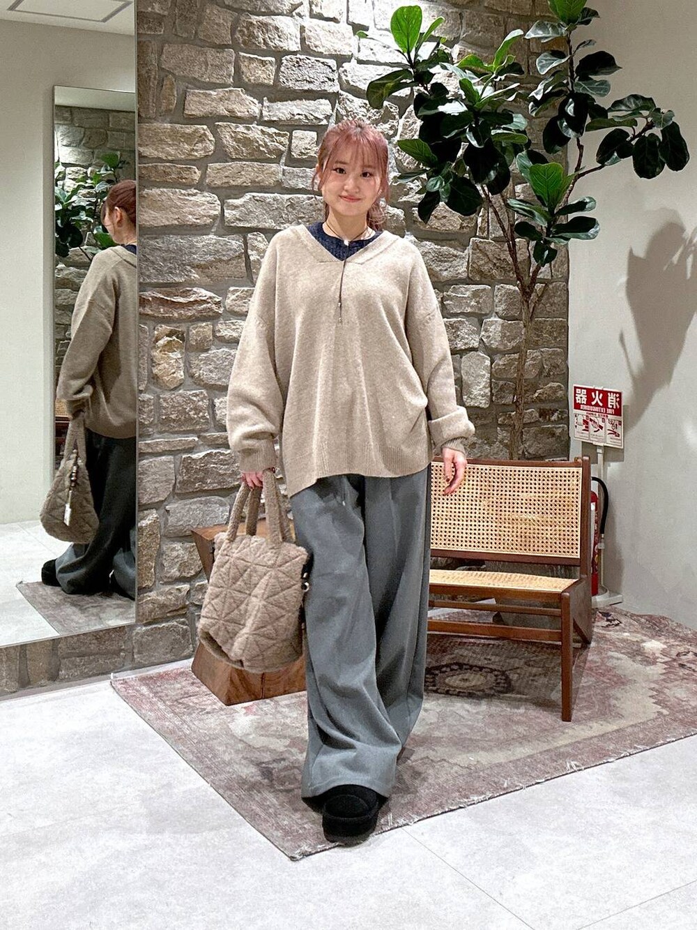 ブラウン系のショルダーバッグ、ベージュ系のニット/セーター、グレー系のその他パンツを着用したレディースの冬コーディネートの2枚目の写真