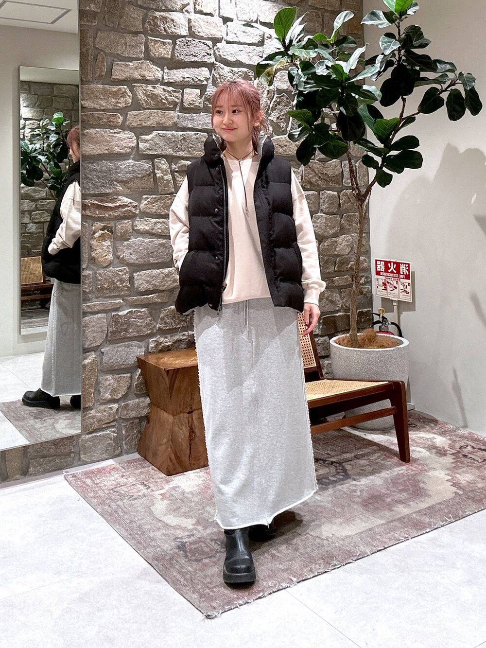 ブラック系のベスト、グレー系のスカートを着用したレディースの冬コーディネートの2枚目の写真