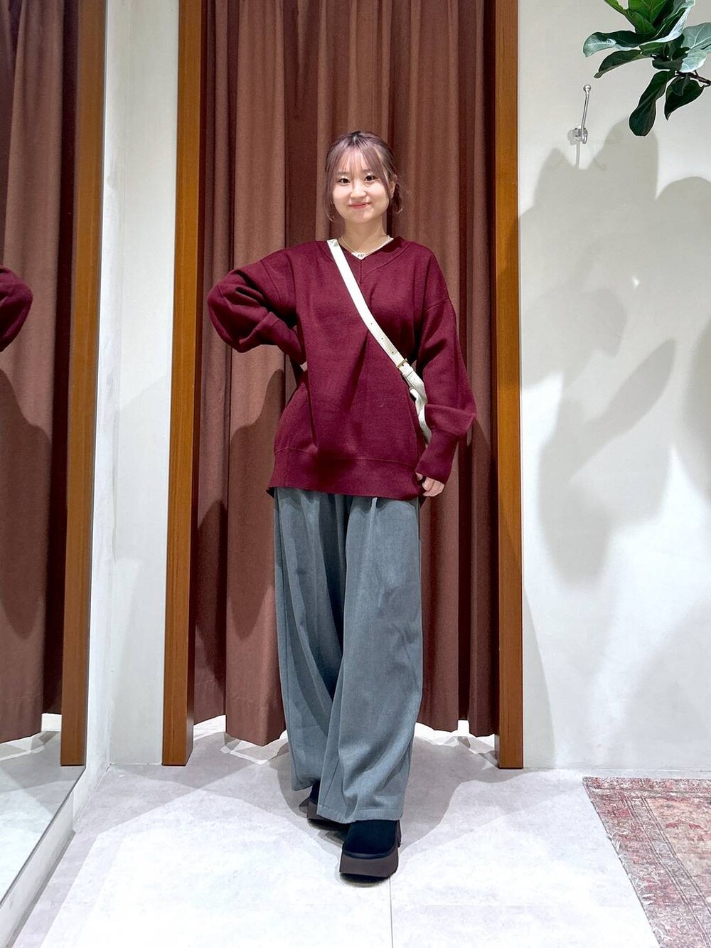 ホワイト系のハンドバッグ、レッド系のニット/セーター、グレー系のその他パンツを着用したレディースの秋コーディネートの2枚目の写真