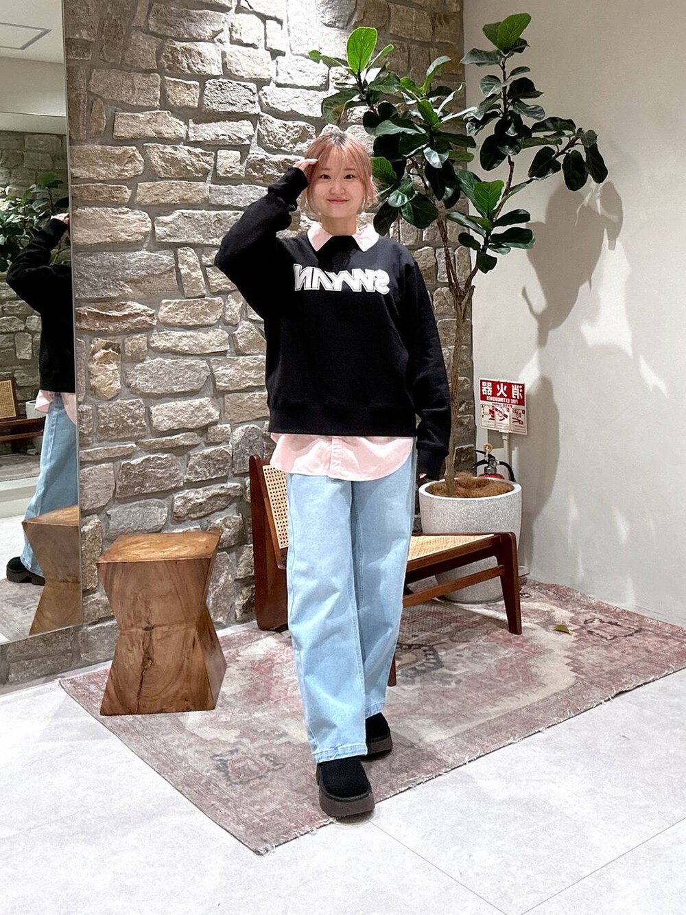 ブルー系のデニムパンツ、ピンク系のシャツ/ブラウス、ブラック系のスウェットを着用したレディースの冬コーディネートの2枚目の写真