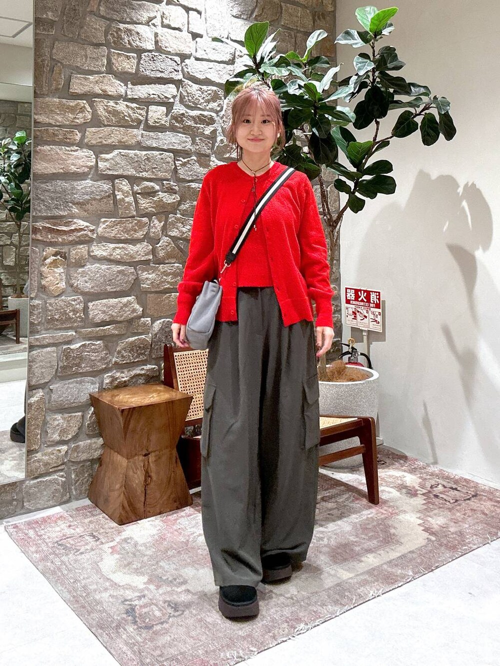 グレー系のショルダーバッグ、グレー系のその他パンツ、レッド系のニット/セーターを着用したレディースの冬コーディネートの2枚目の写真