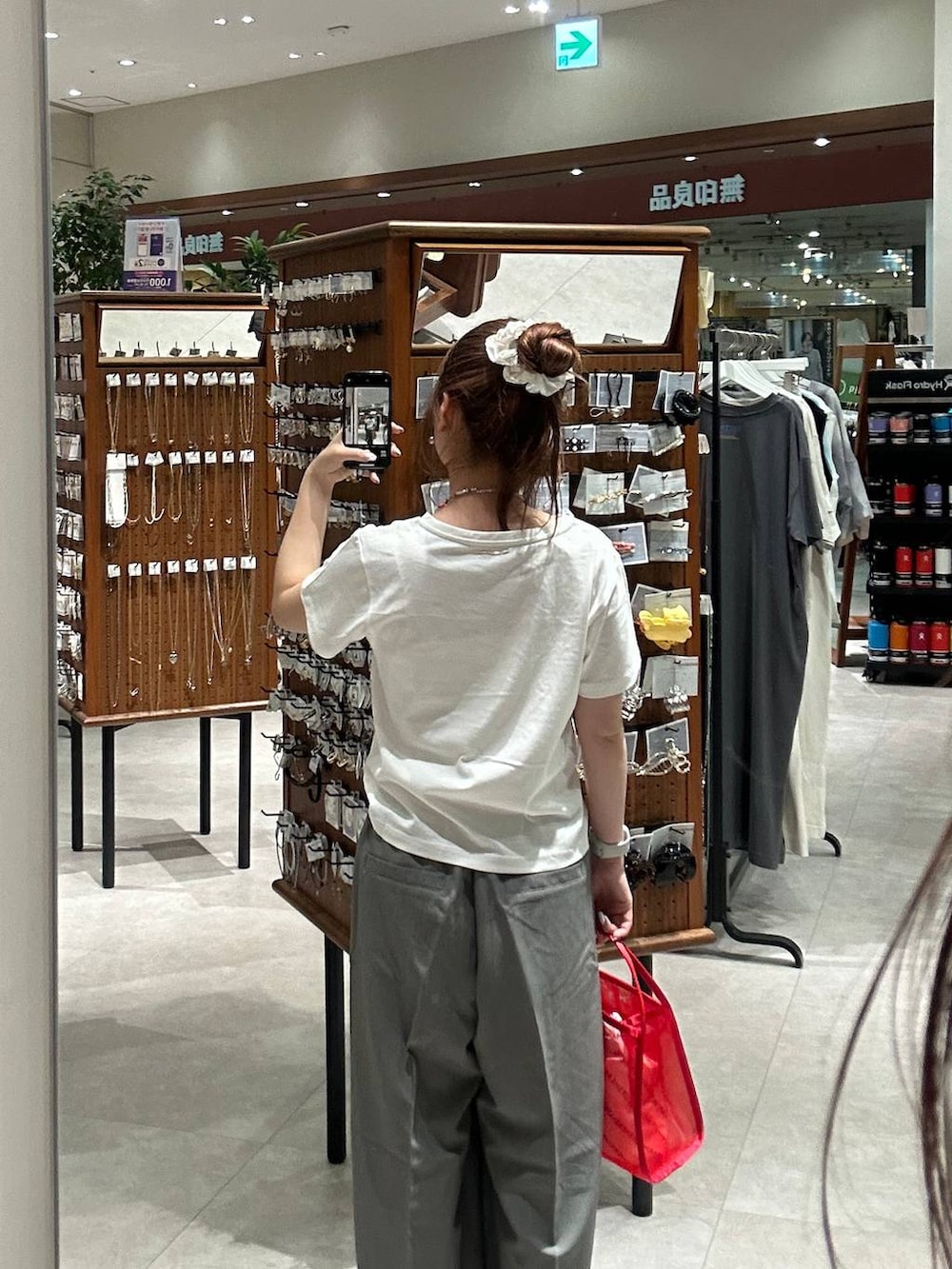 レッド系のハンドバッグ、グレー系のその他パンツ、ホワイト系のTシャツ/カットソーを着用したレディースの夏コーディネートの2枚目の写真