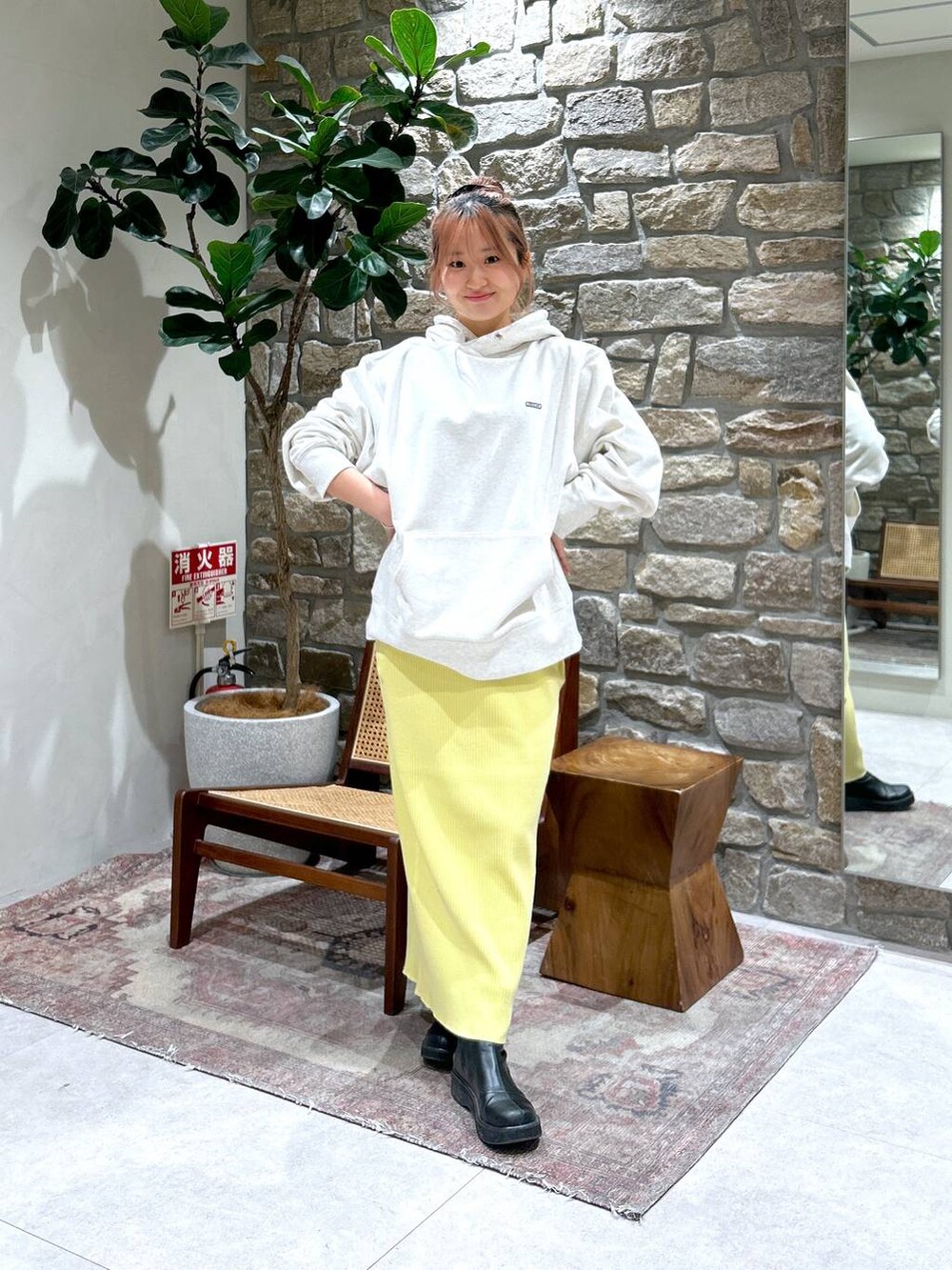 イエロー系のスカート、グレー系のパーカーを着用したレディースの冬コーディネートの2枚目の写真