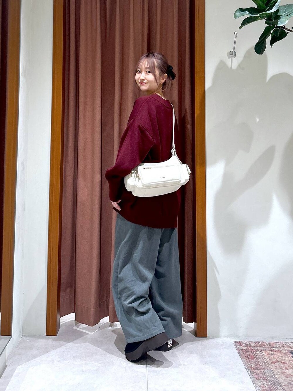 ホワイト系のハンドバッグ、レッド系のニット/セーター、グレー系のその他パンツを着用したレディースの秋コーディネートの4枚目の写真