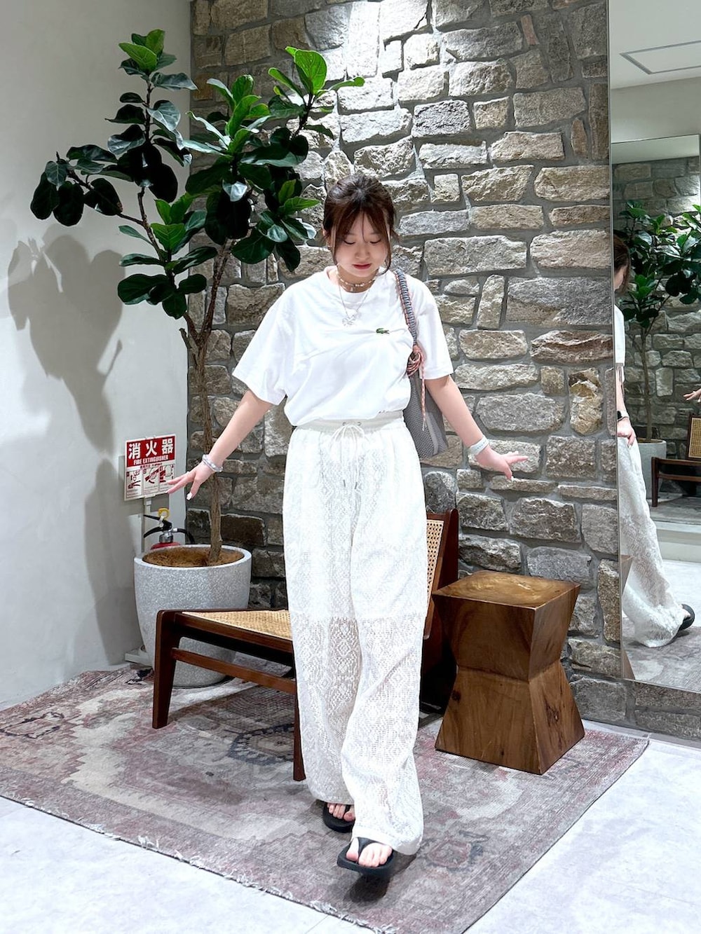 グレー系のハンドバッグ、ホワイト系のその他パンツ、ブラック系のサンダルを着用したレディースの春コーディネートの2枚目の写真